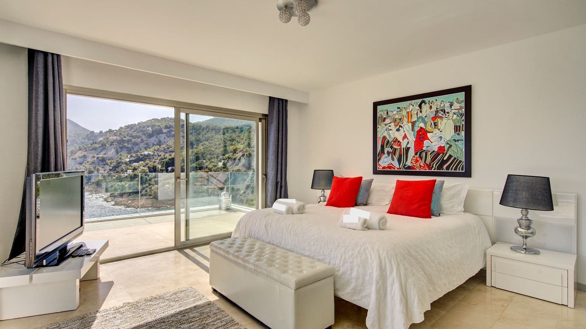 Bedroom with colourful artwork and views over the surrounding hills