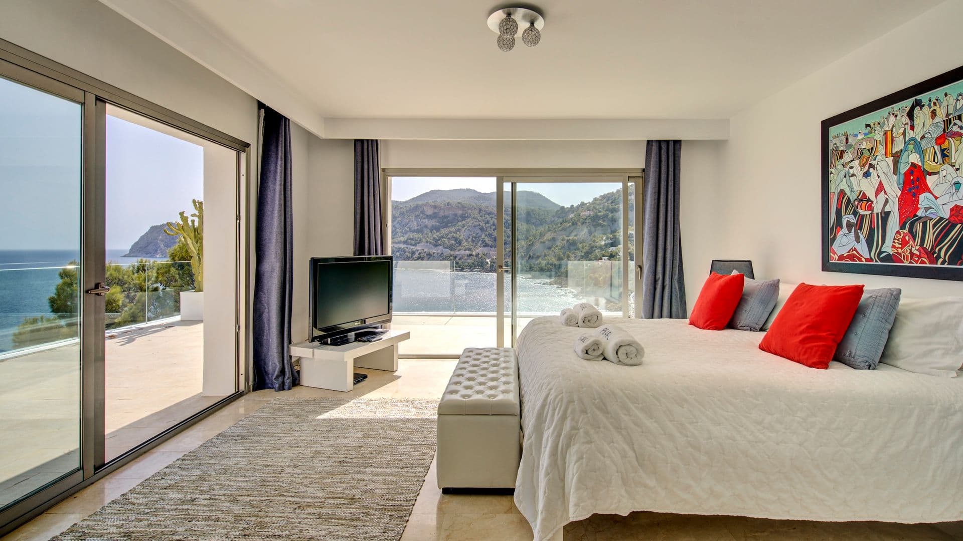 Bedroom with television and sliding doors opening onto the terrace