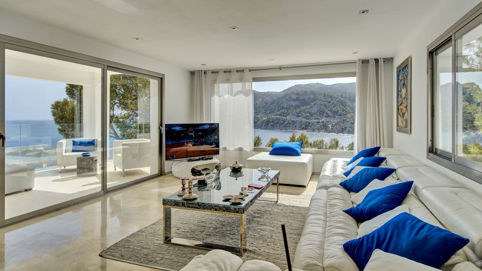 Living room with floor to ceiling glass doors framing a panoramic sea view