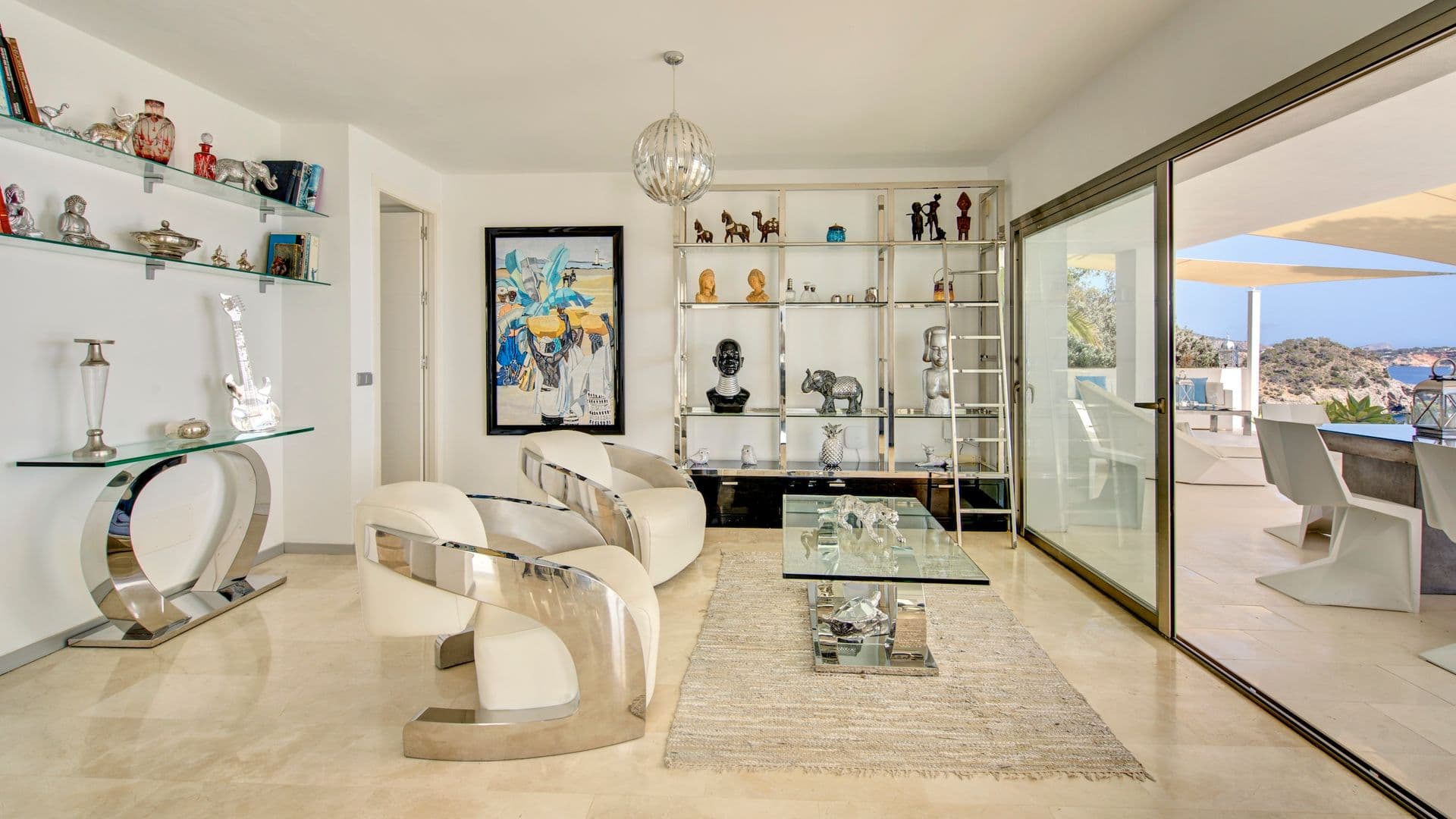 Sitting area with white curved chairs and a glass coffee table
