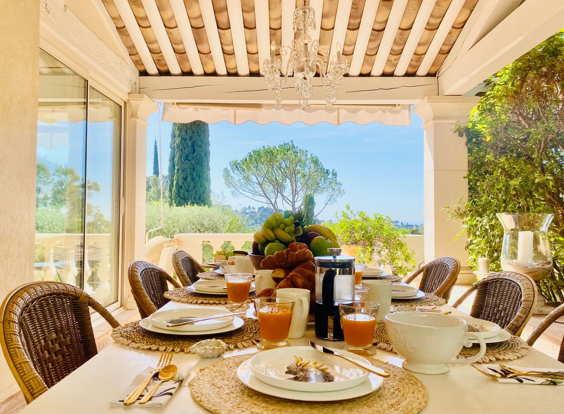 Breakfast laid on the covered terrace with fresh fruit and juice.