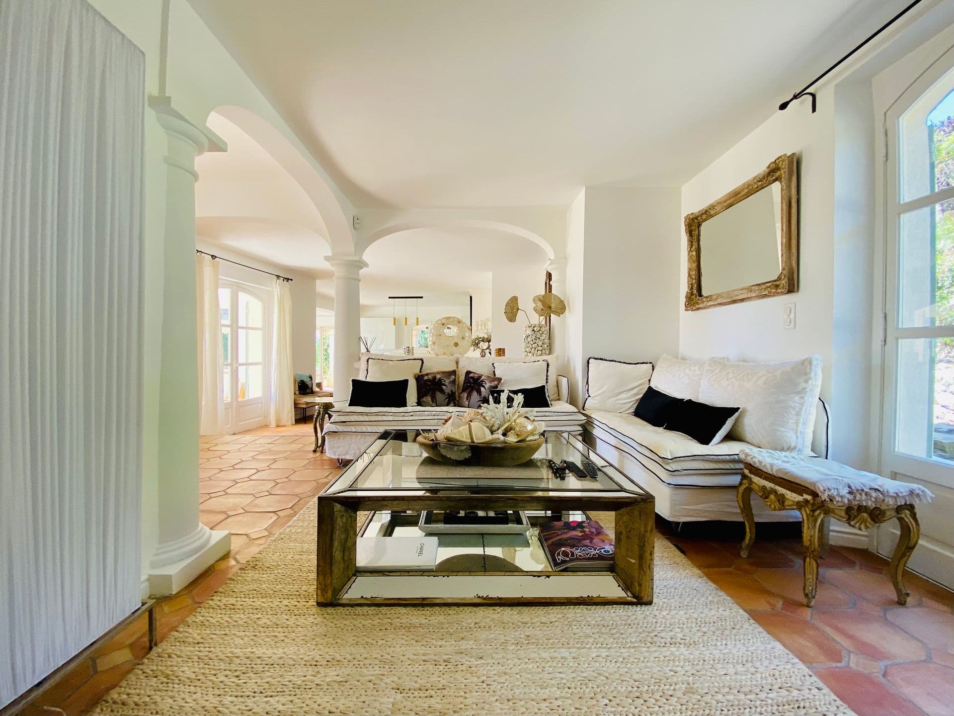 Living room with terracotta floors and an arched doorway to the hall.