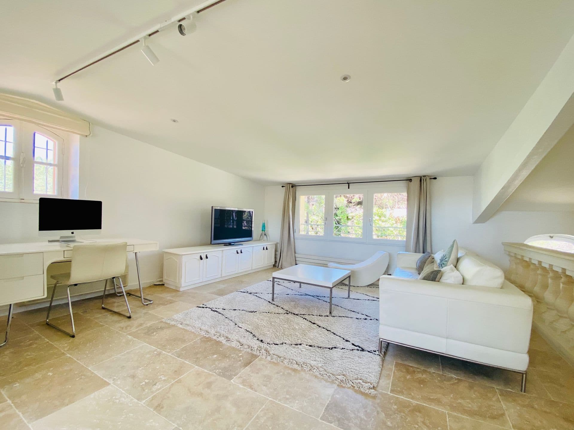 Bright study with a white desk and garden-facing window.