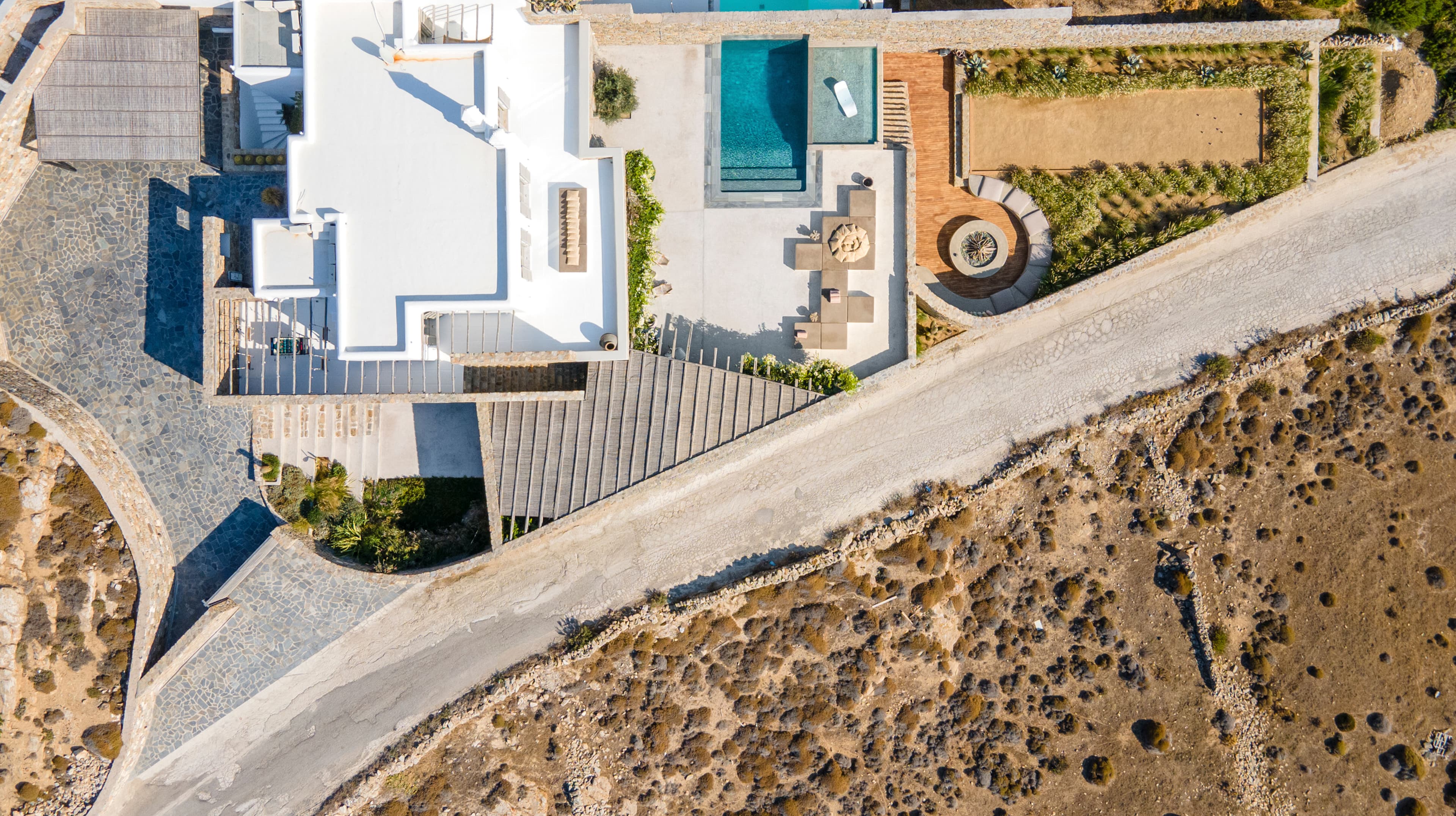 Villa Iliada aerial view showing pool, terraces and hillside layout, Mykonos, Greece
