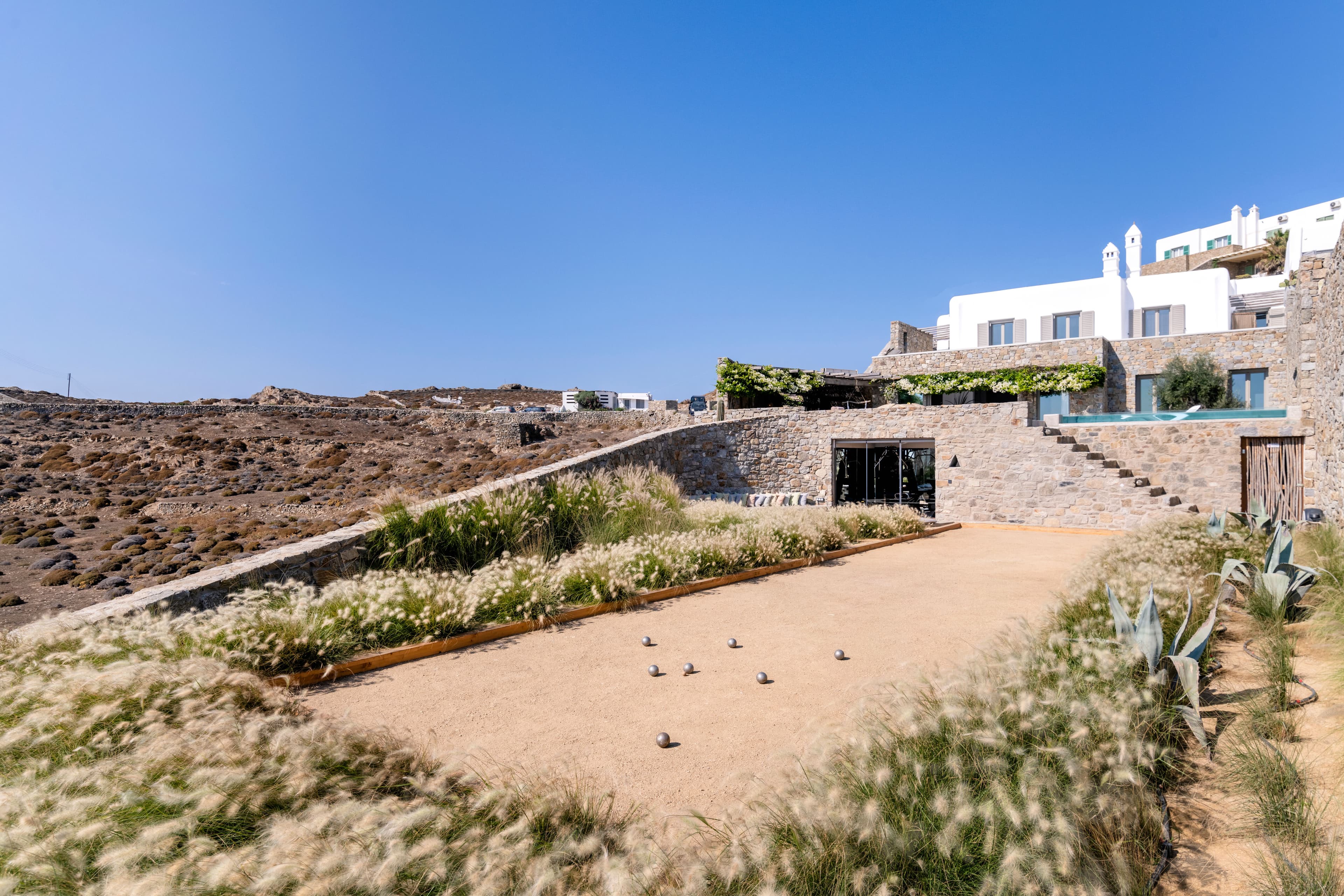 Villa Iliada exterior with contemporary landscaping and stone construction, Mykonos, Greece