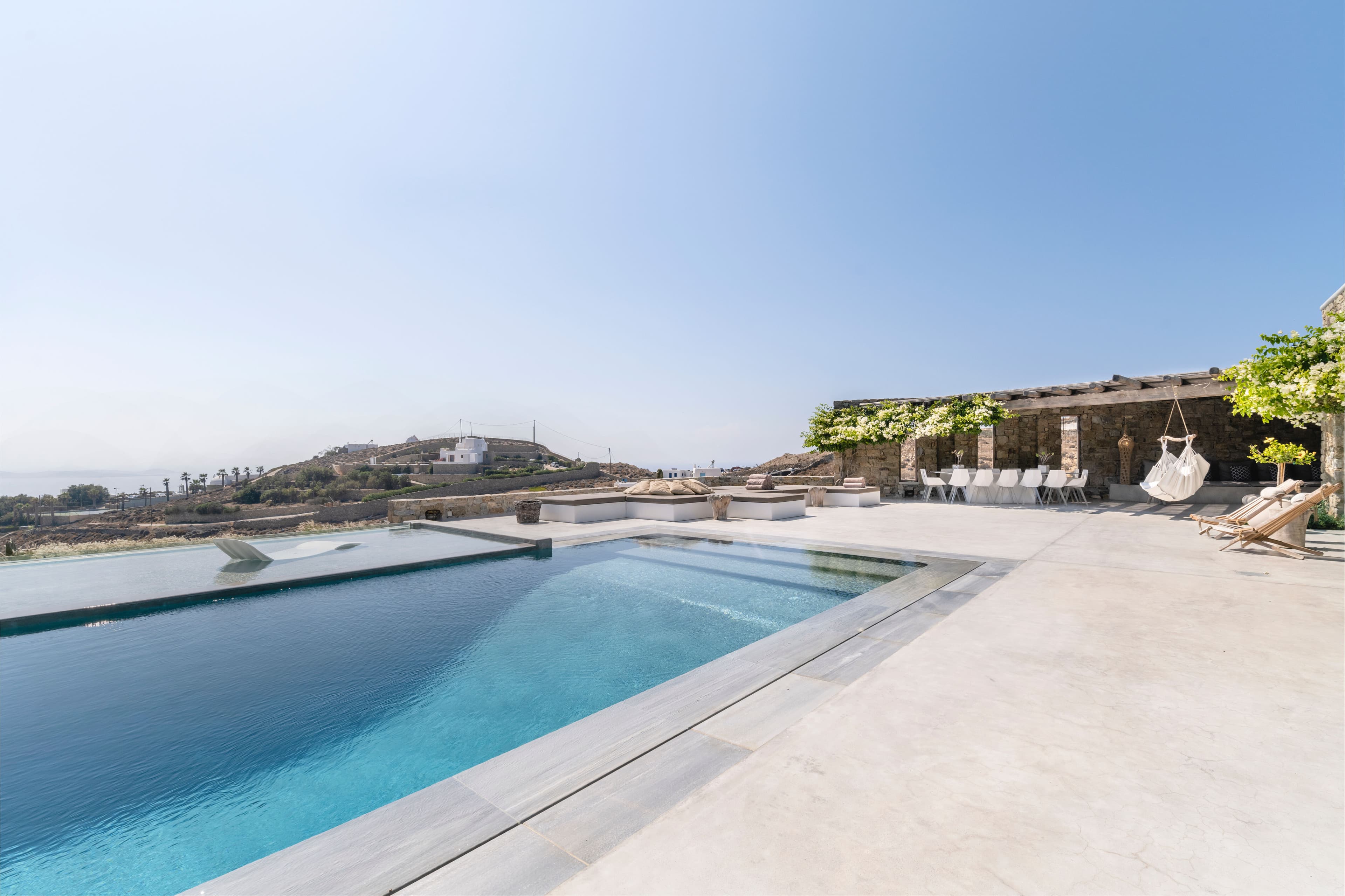 Villa Iliada infinity pool with stone pergolas and sea views, Mykonos, Greece
