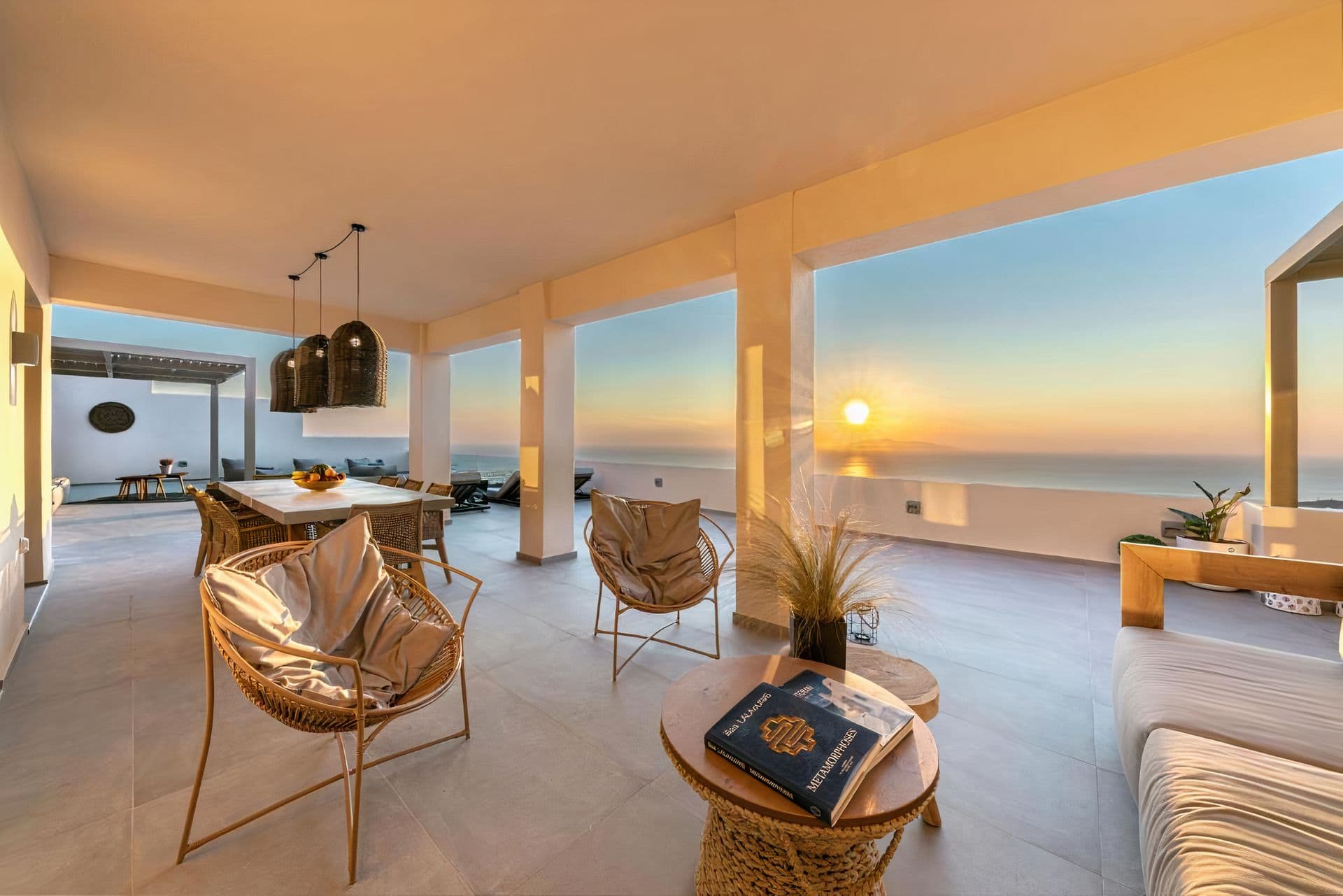Covered stone terrace with teal cushioned lounge seating at Grecian Gazing