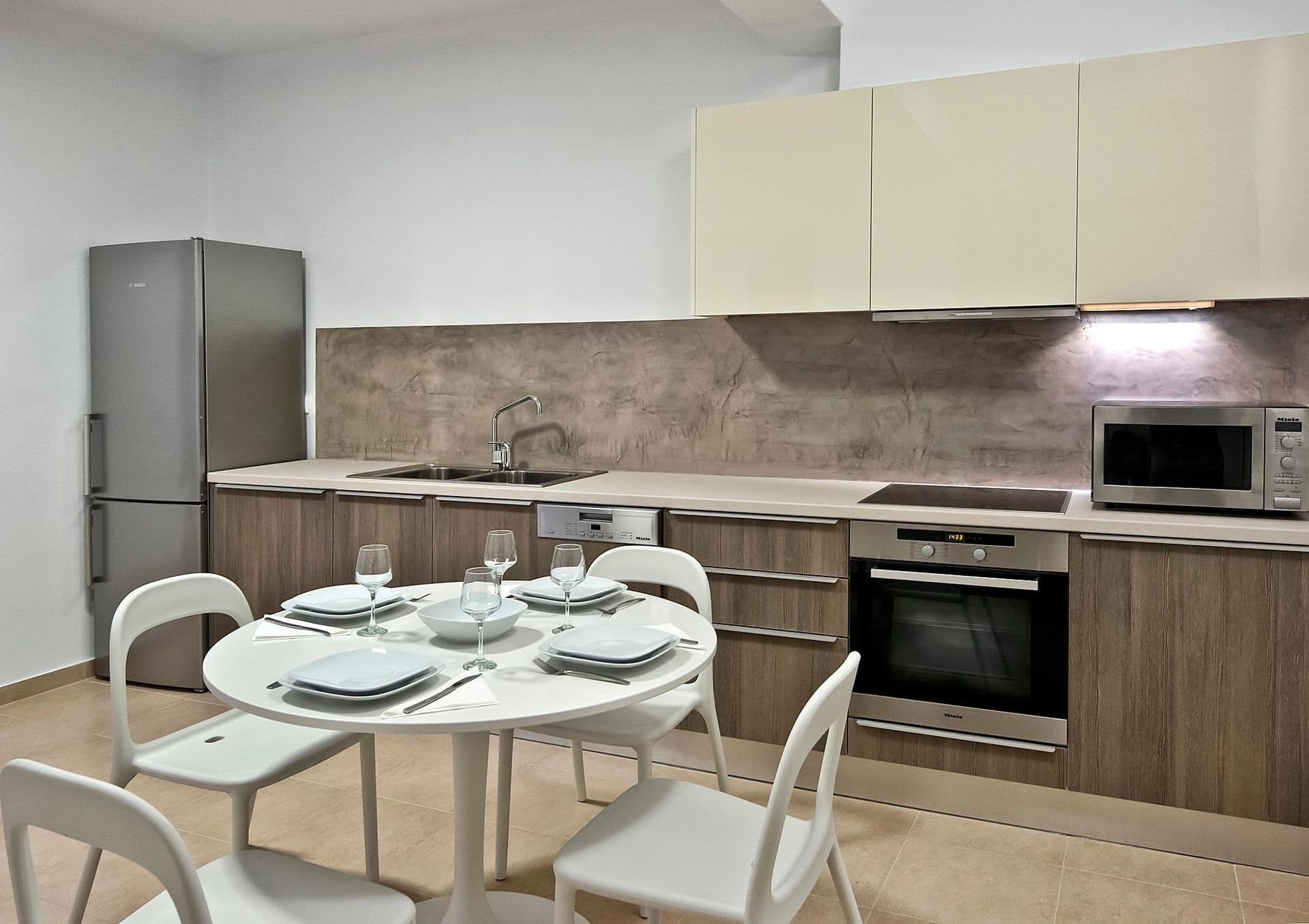 Modern fitted kitchen with cream cabinetry and integrated appliances at Grecian Gazing
