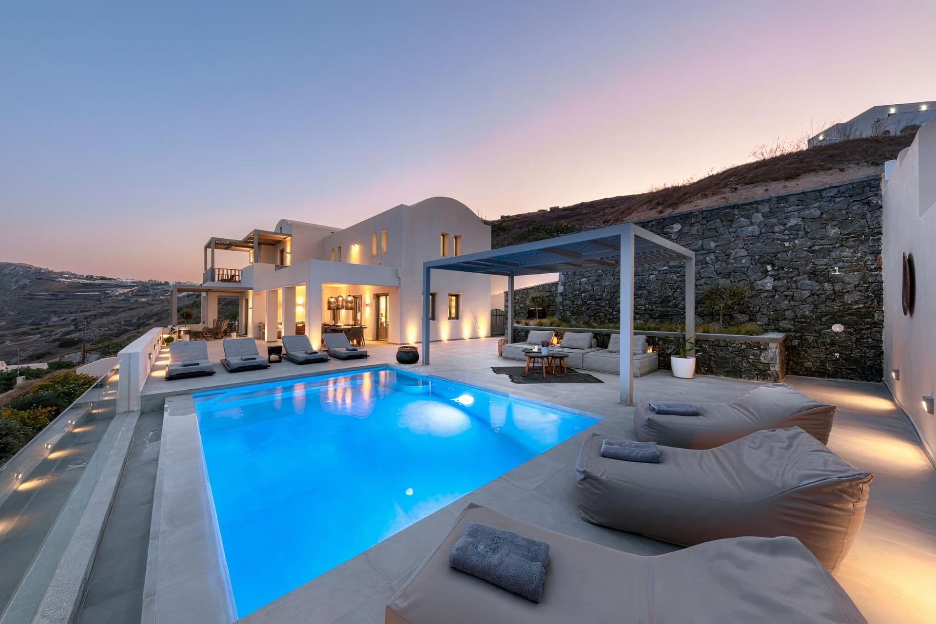 Open-plan living and dining area glowing at sunset with sea view at Grecian Gazing