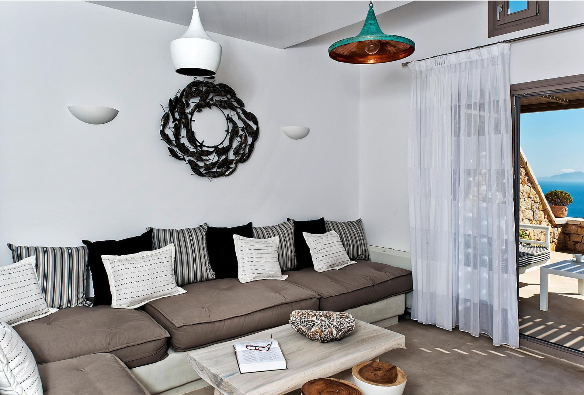 Living room with grey L-shaped sofa and striped cushions at Grecian Gazing