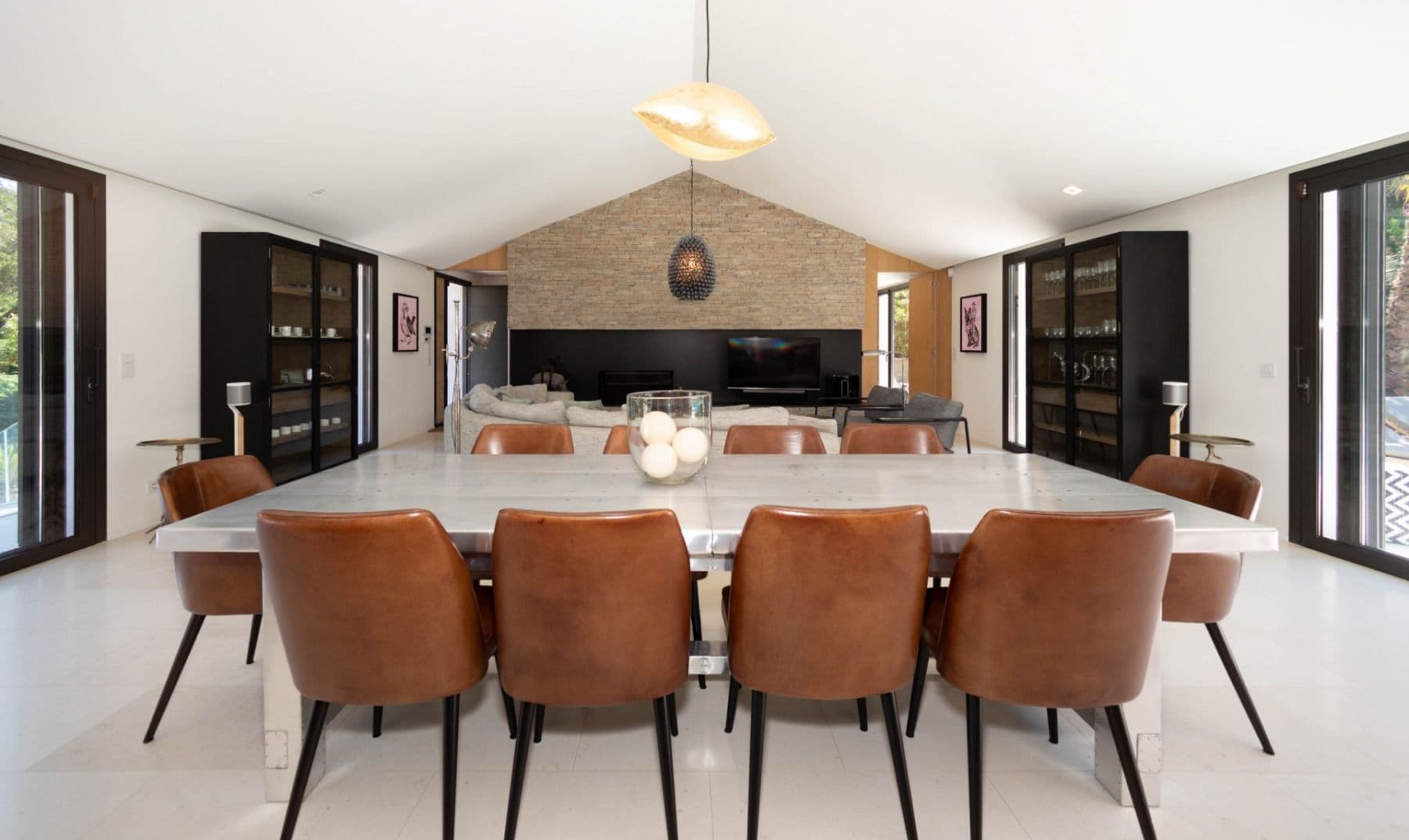 Dining table for twelve with tan leather chairs and glazed wine cabinets at Brilliant Sea, Saint-Tropez