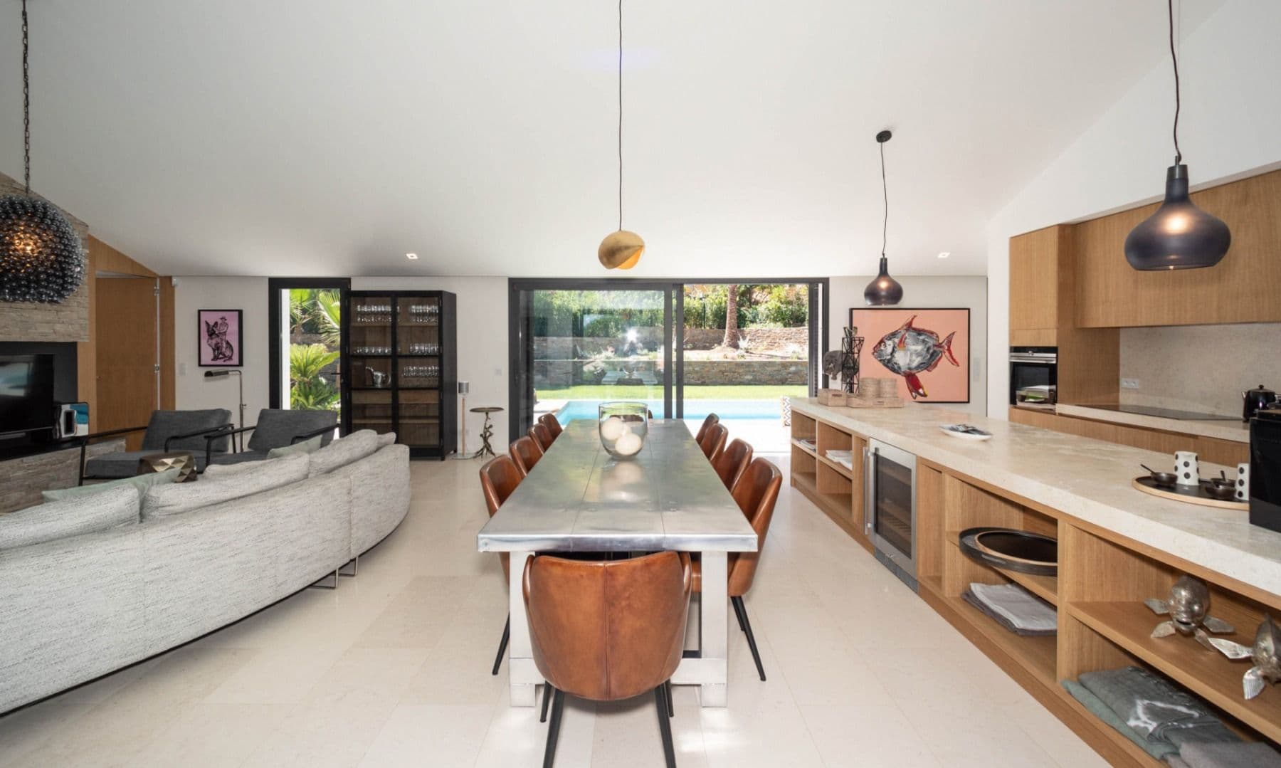 Open-plan living, dining and kitchen with a curved sofa and long table at Brilliant Sea, Saint-Tropez