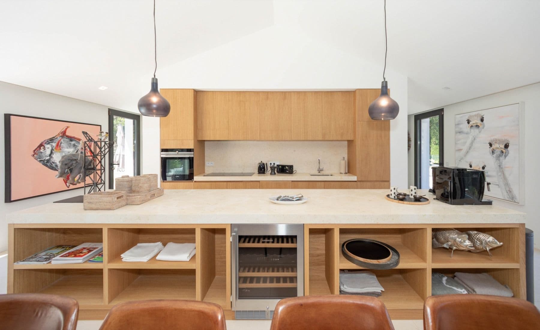 Kitchen with an oak and travertine island below pop-art at Brilliant Sea, Saint-Tropez