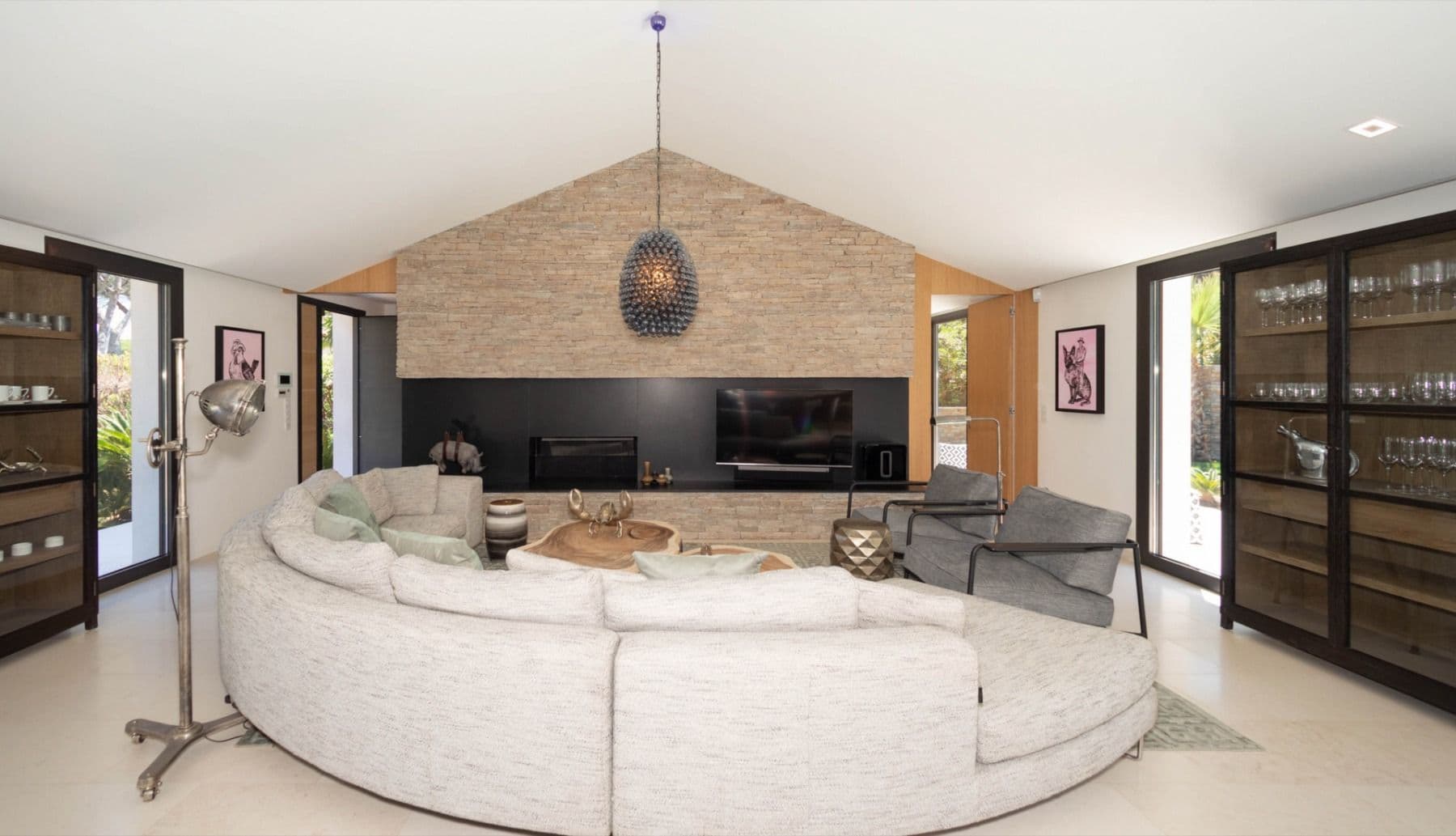 Living room with a round sofa, fireplace and stone gable wall at Brilliant Sea, Saint-Tropez