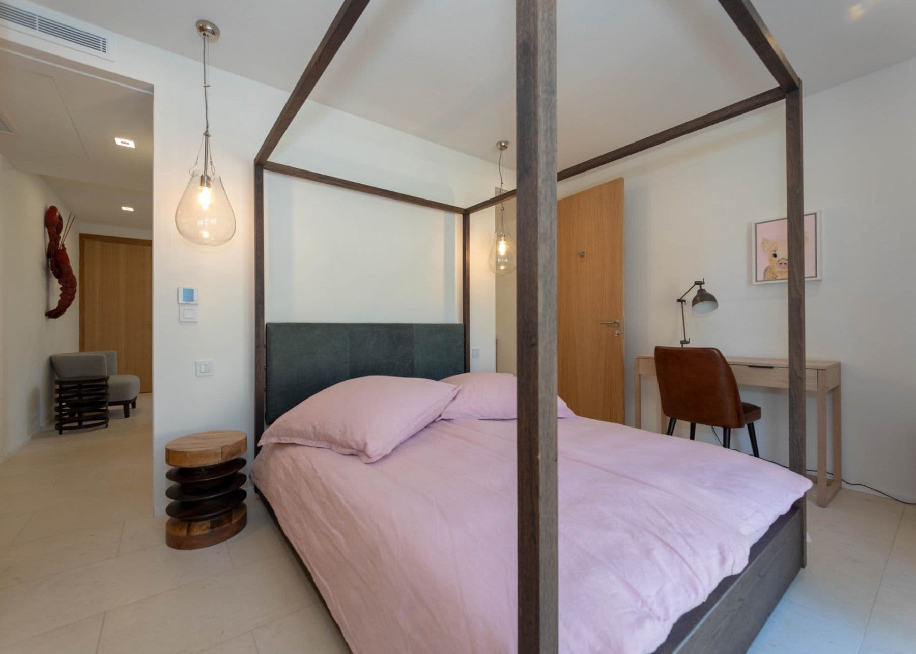 Master bedroom with a timber four-poster frame and a study corner at Brilliant Sea, Saint-Tropez