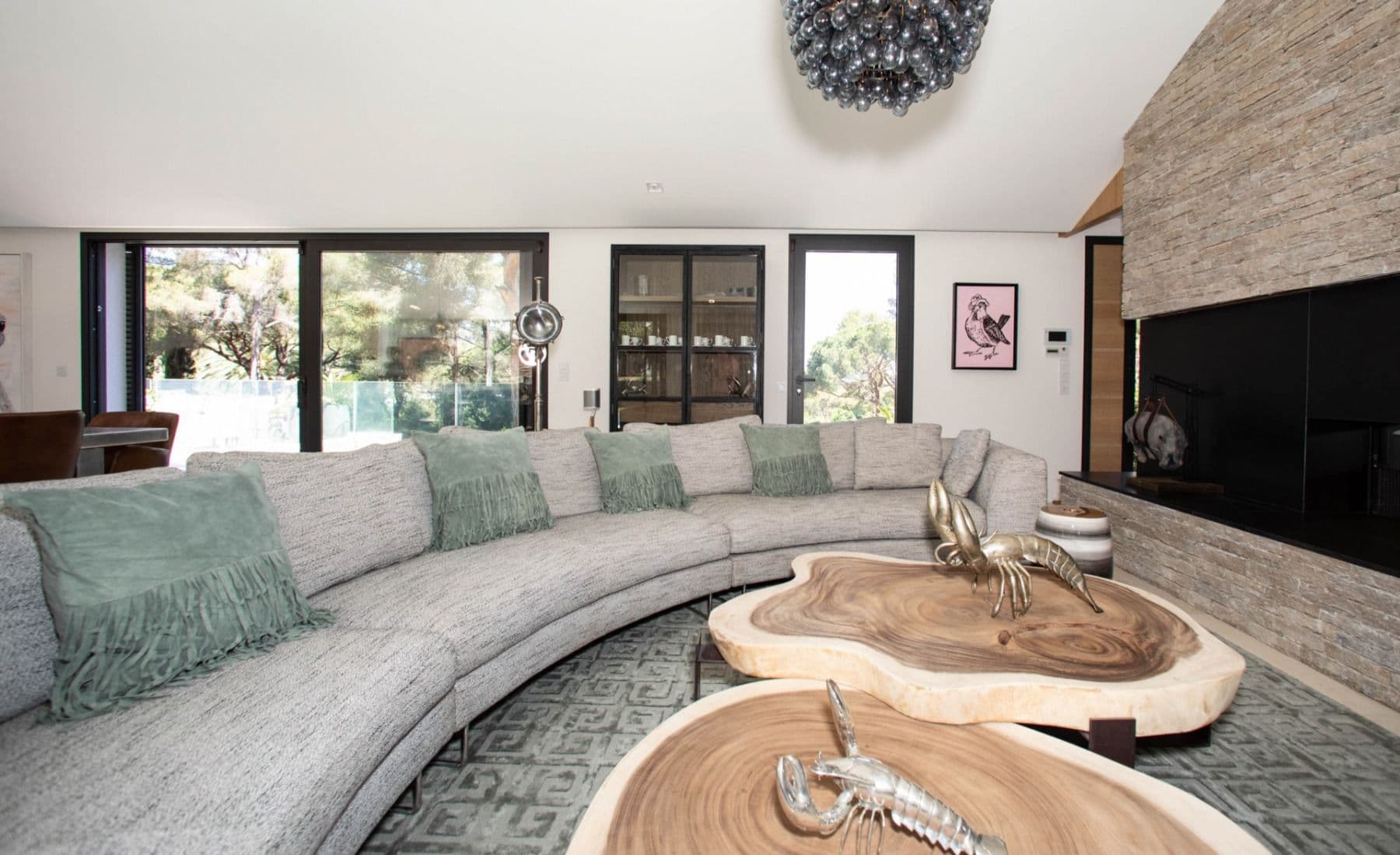 Sitting area with a curved grey sofa and live-edge tables at Brilliant Sea, Saint-Tropez