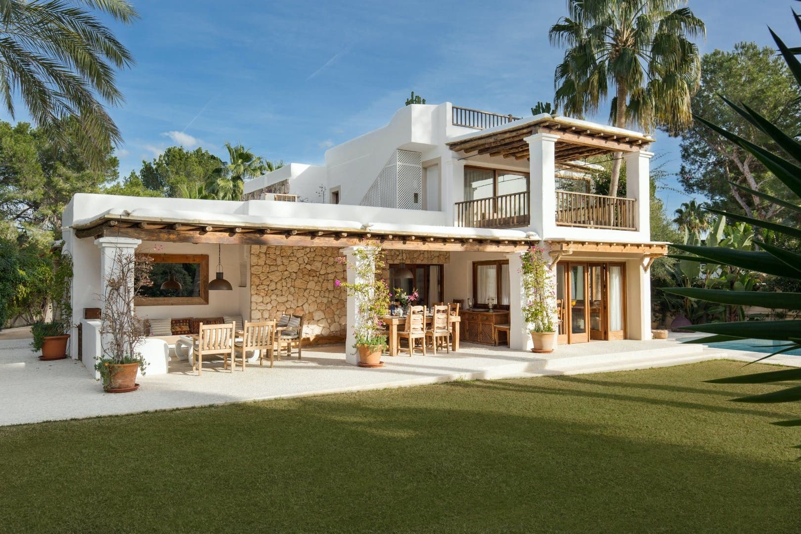 Two-storey whitewashed finca with wraparound balcony and lawn