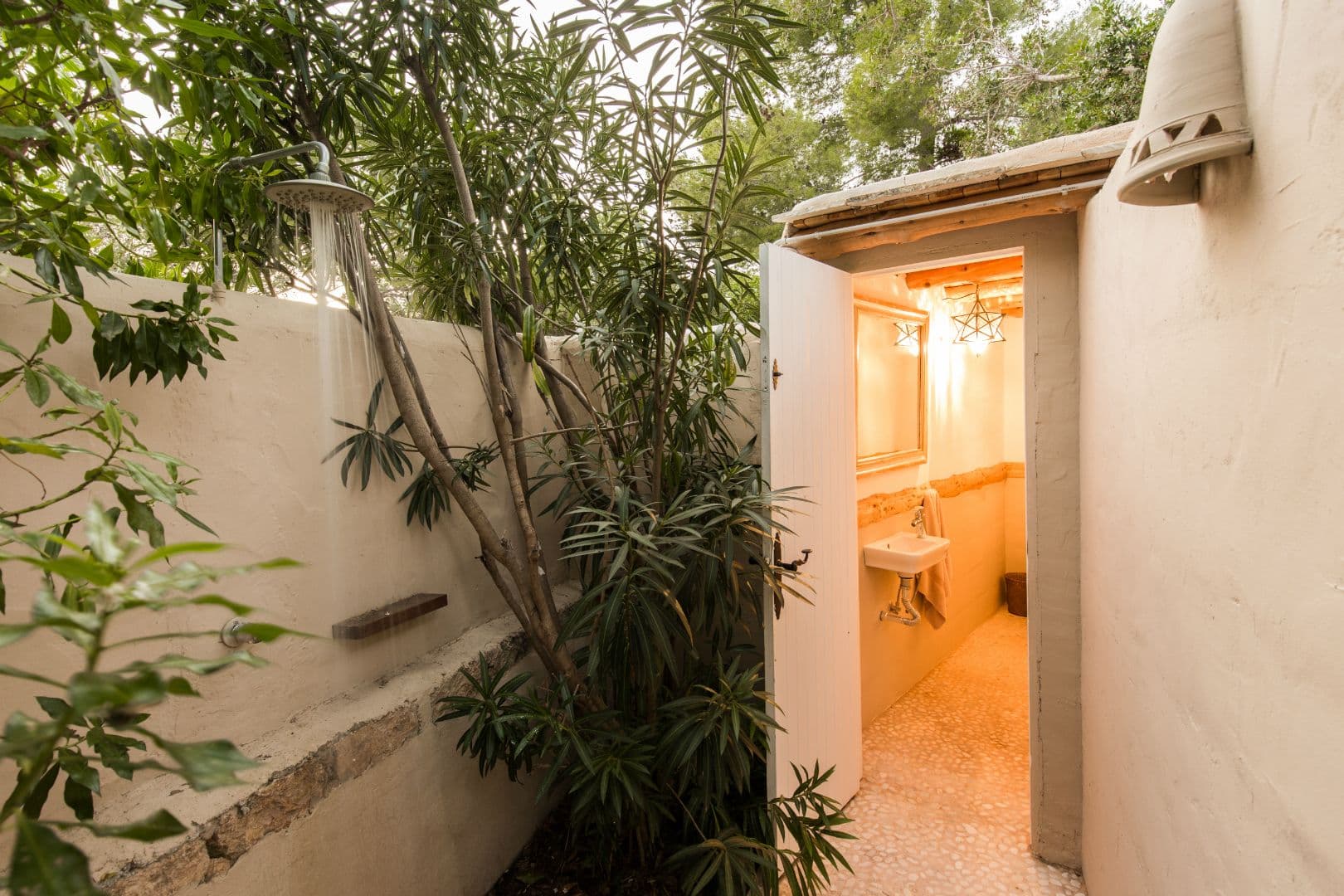 Garden pathway leading to an outdoor bathroom entrance