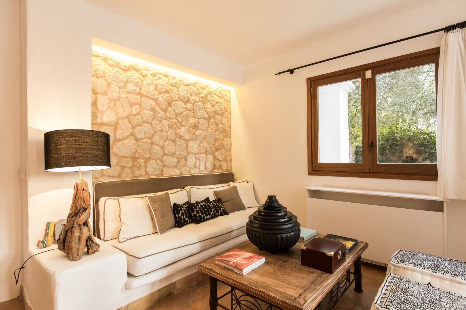 Second living area with cream sofa and stone feature wall