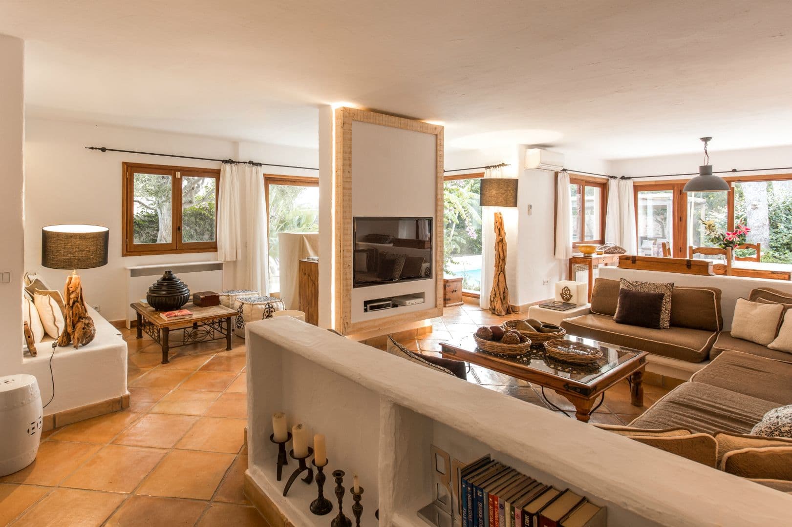 Living room with sectional sofa, television and rustic tiled floor