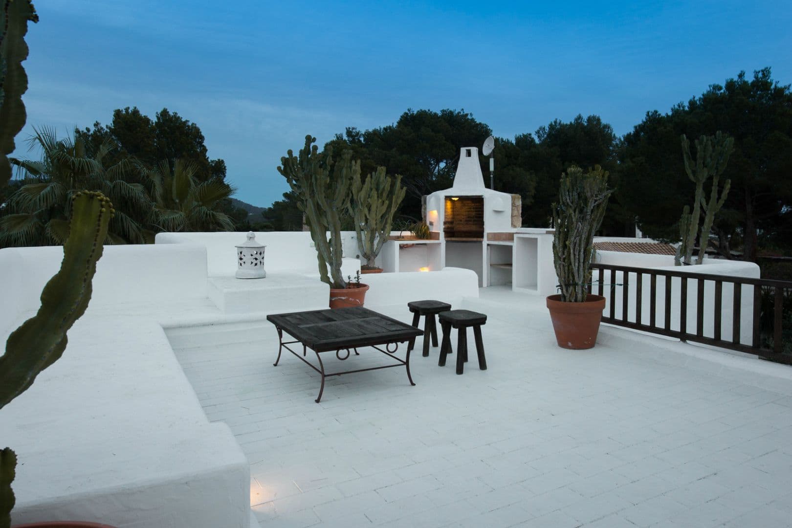 Rooftop terrace with an outdoor kitchen and seating at dusk