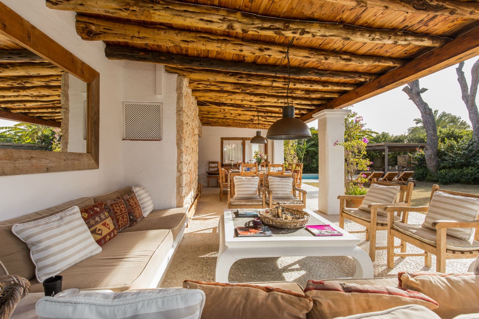 Covered terrace lounge with cushioned seating under a beamed ceiling