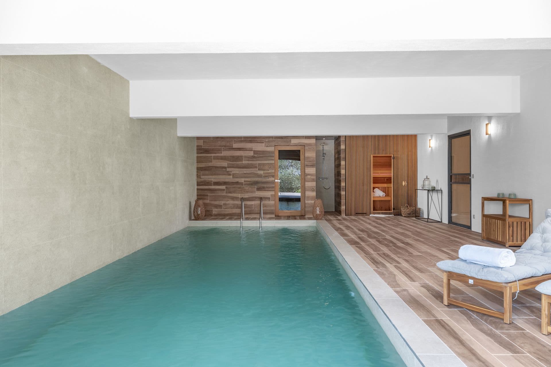 Indoor pool with a sauna and timber decking at Alpilles Retreat, Provence
