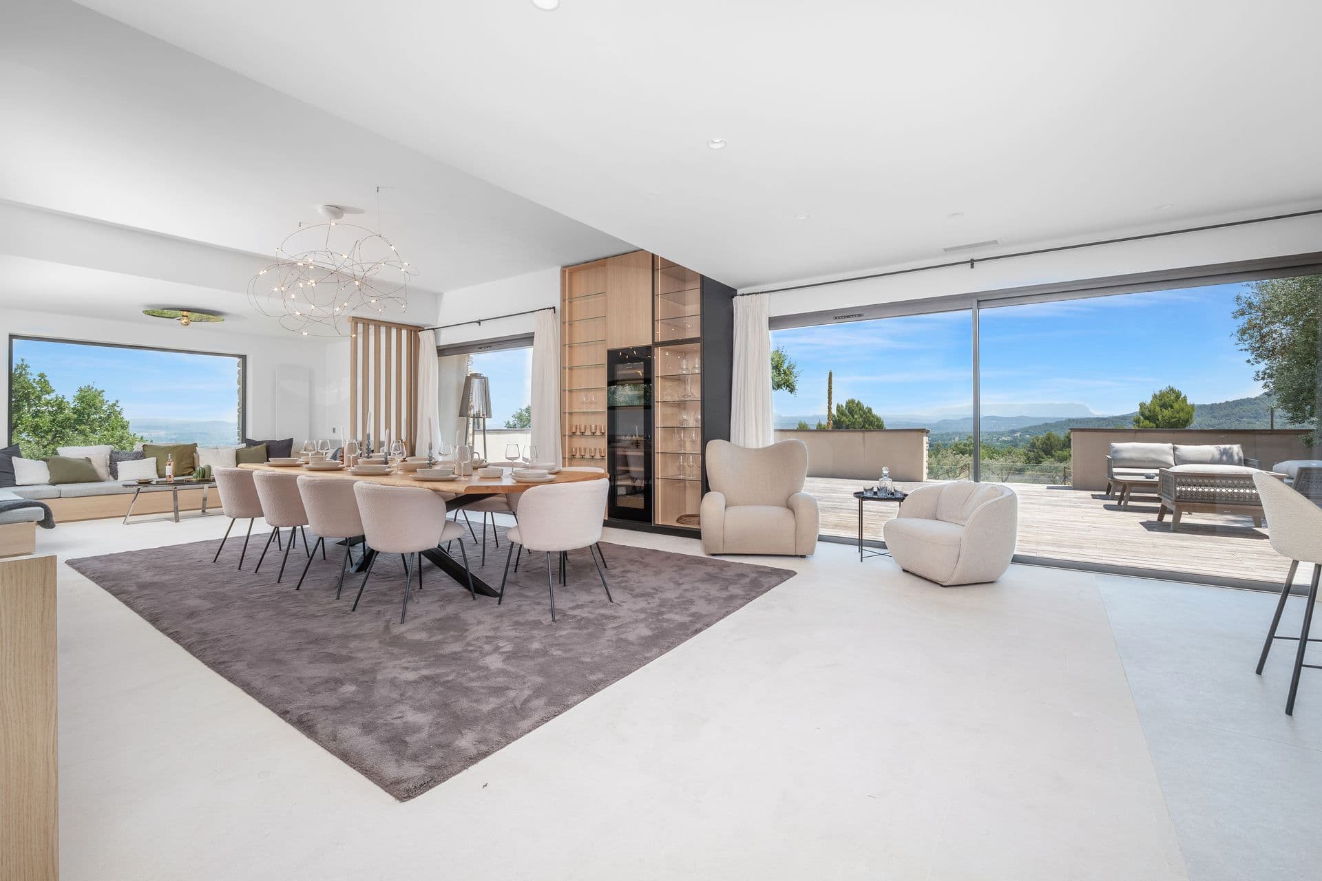 Living and dining room with full-height windows onto the terrace at Alpilles Retreat, Provence