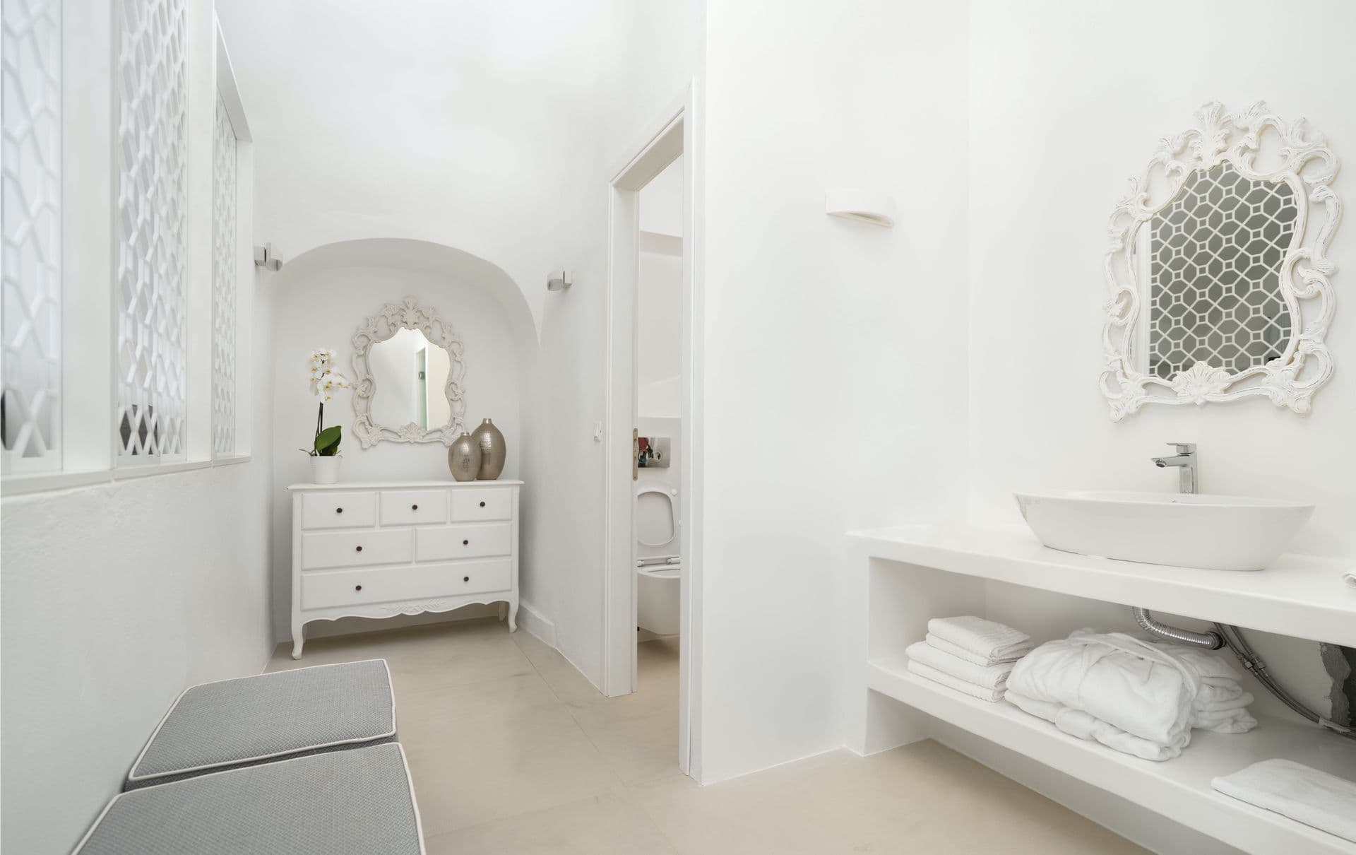 White bathroom with a vessel basin and ornate mirror at Calypso Dream, Santorini