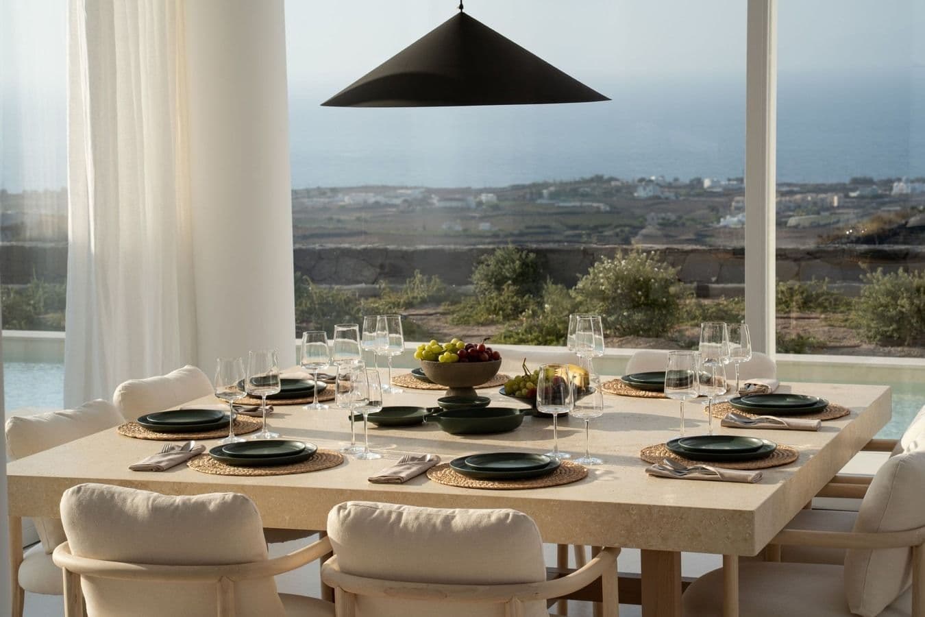 Dining table set for a meal with a panoramic sea view beyond