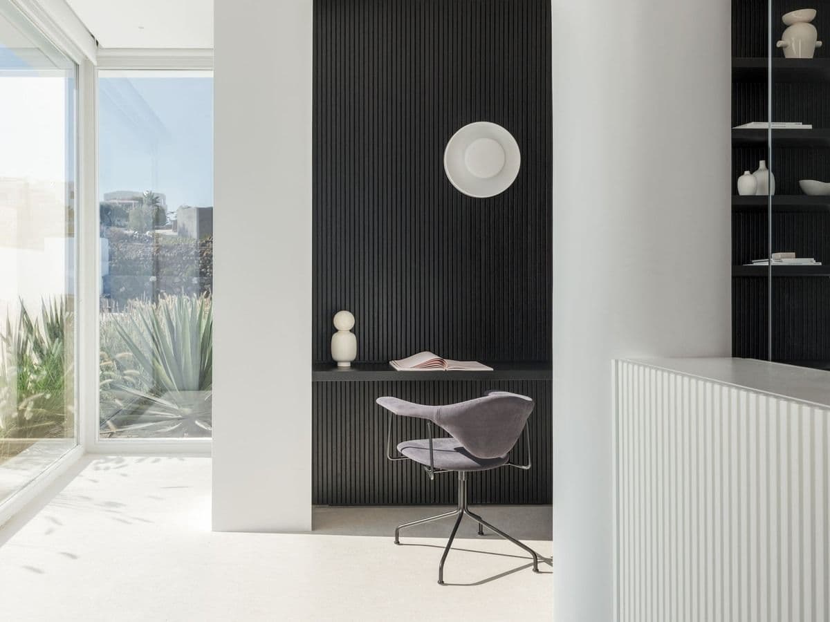 Dark-toned dressing nook with round mirror and desk seating