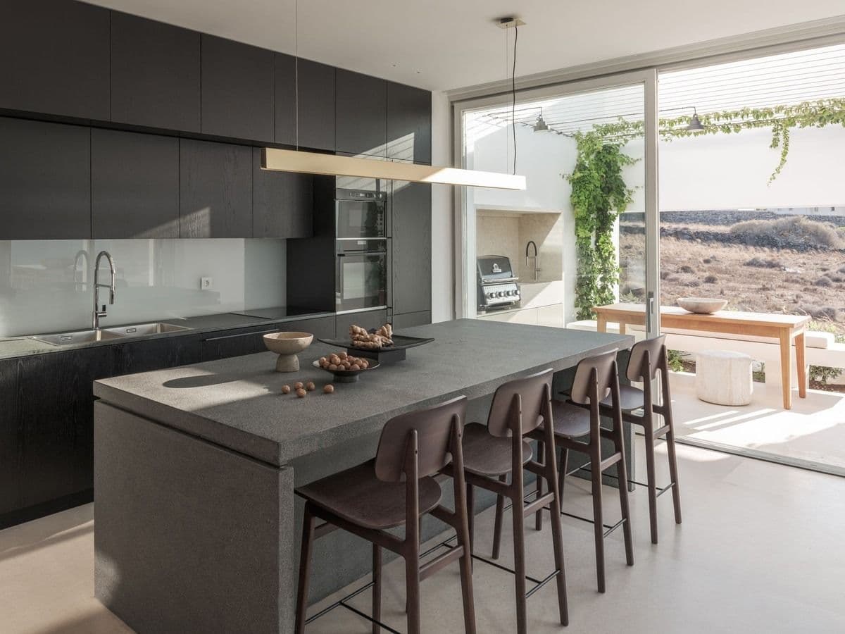 Dark modern kitchen with island counter and bar stool seating