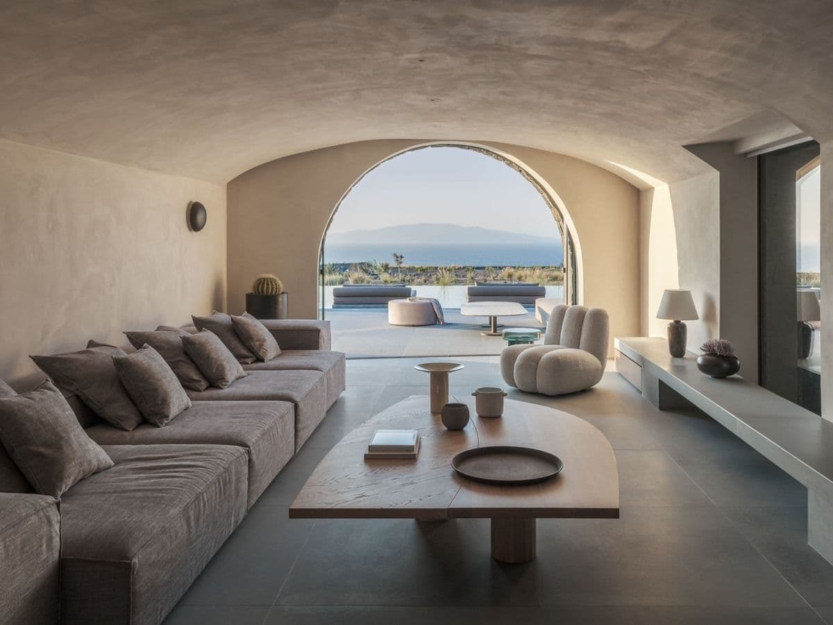 Living area framed by a stone archway opening onto the sea view