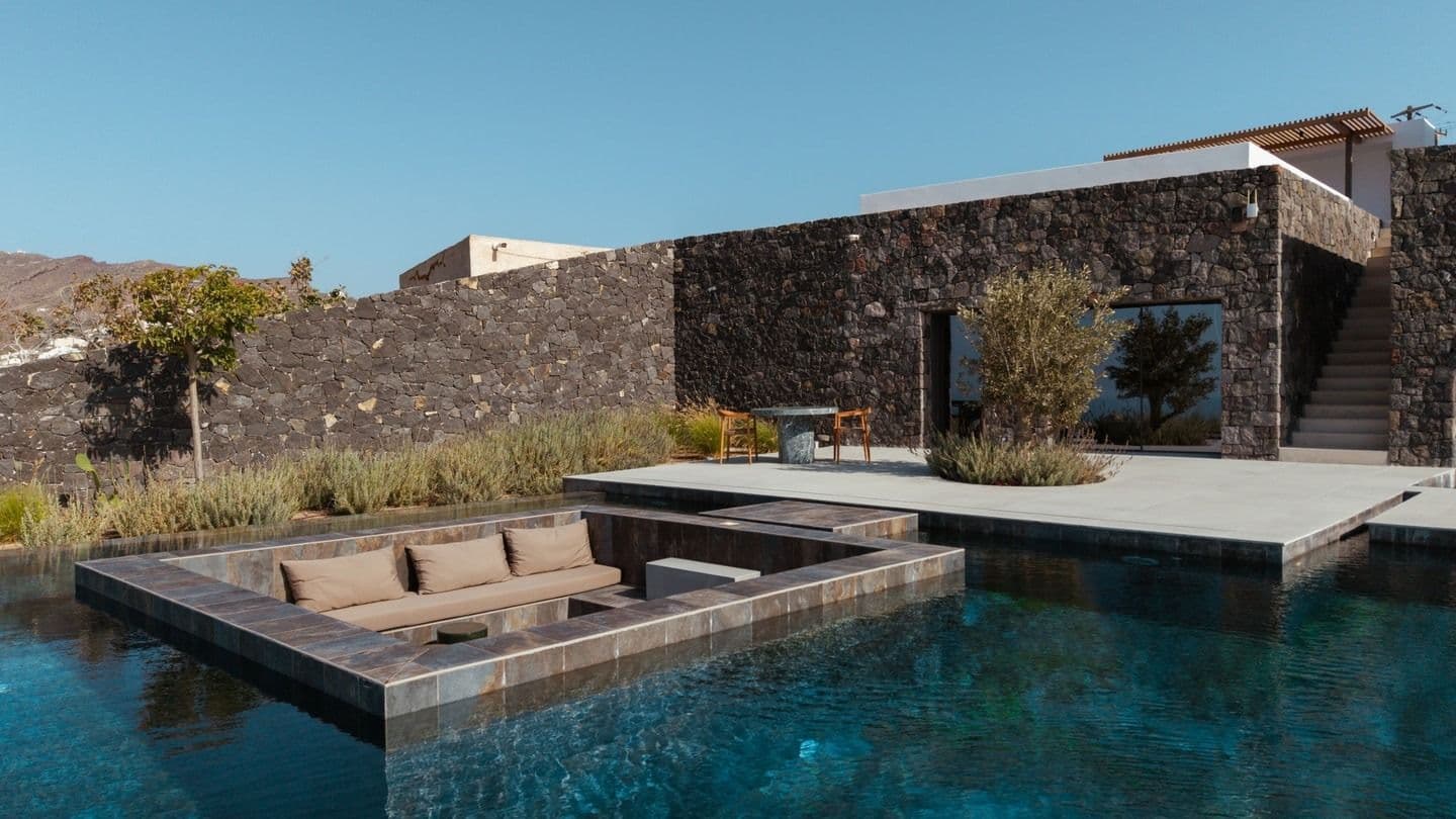 Long dark-tiled pool beside the villa's stone-clad guest wing