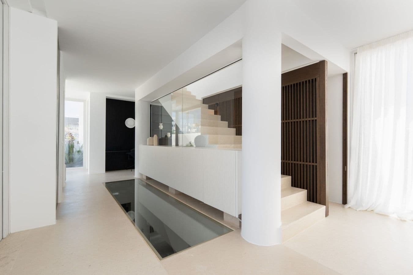 Interior hallway with staircase and a reflective water feature