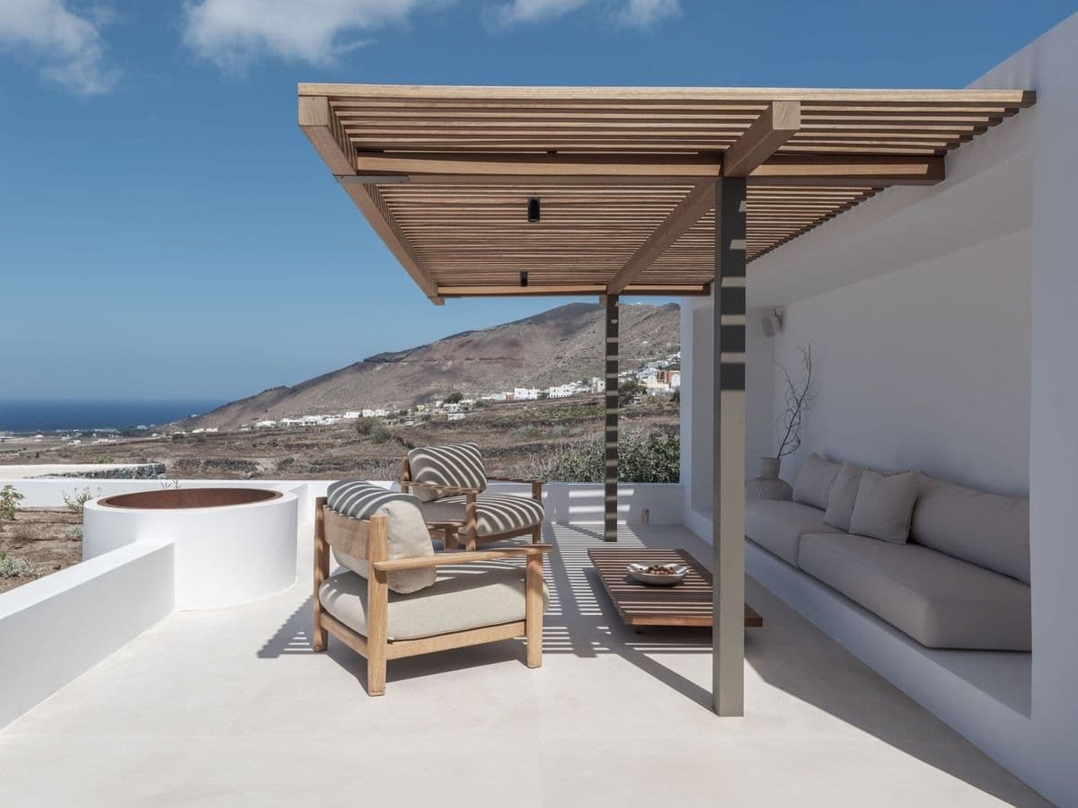 Covered terrace lounge with wooden pergola and distant sea view