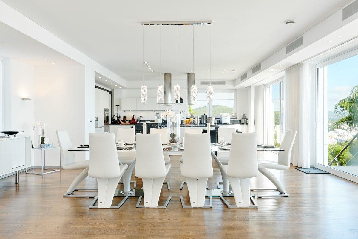 White dining room with sculptural chairs beside the kitchen at Blue Sea Bliss, Ibiza