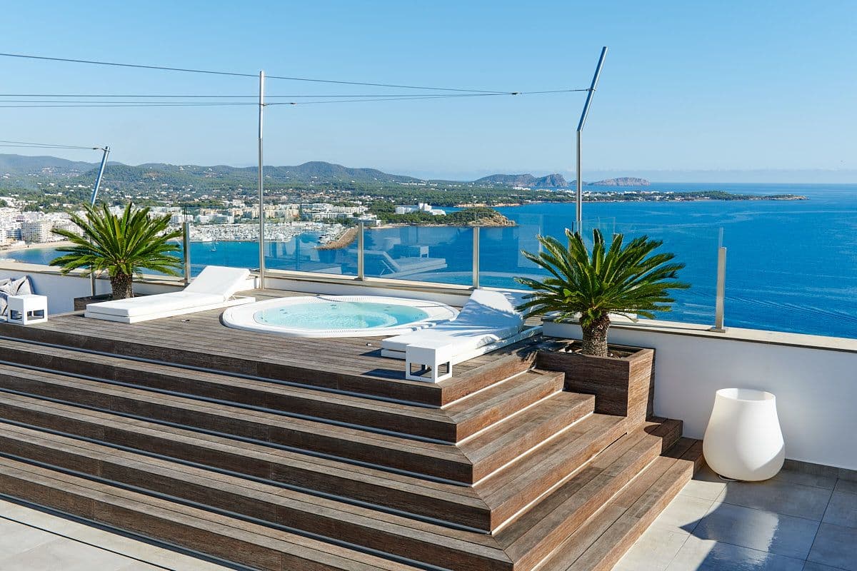Timber-stepped rooftop terrace with a hot tub and bay views at Blue Sea Bliss, Ibiza