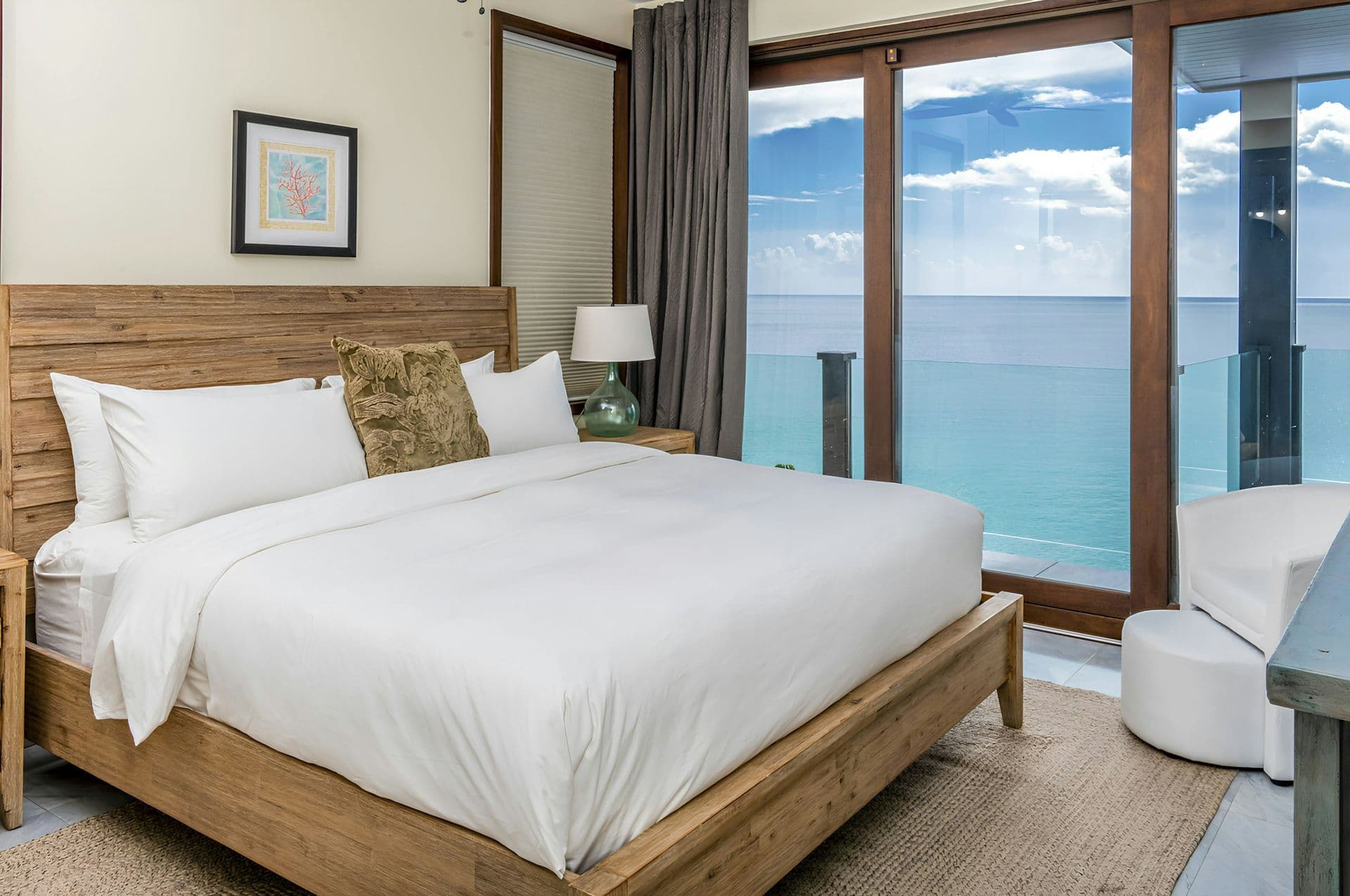 Bedroom with a timber headboard and sea views at Life in Love, Antigua