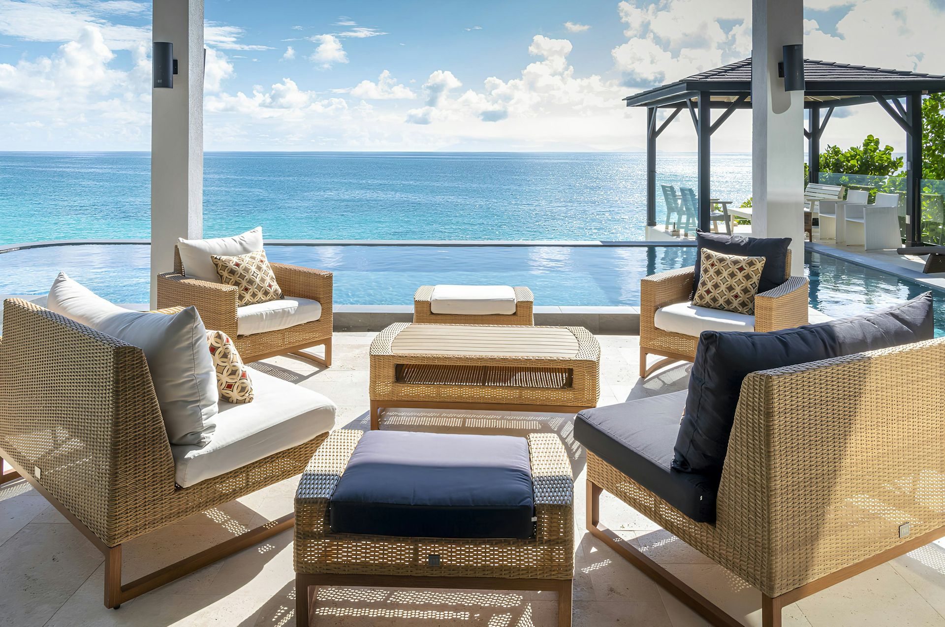 Wicker terrace seating on the edge of the infinity pool over the sea at Life in Love