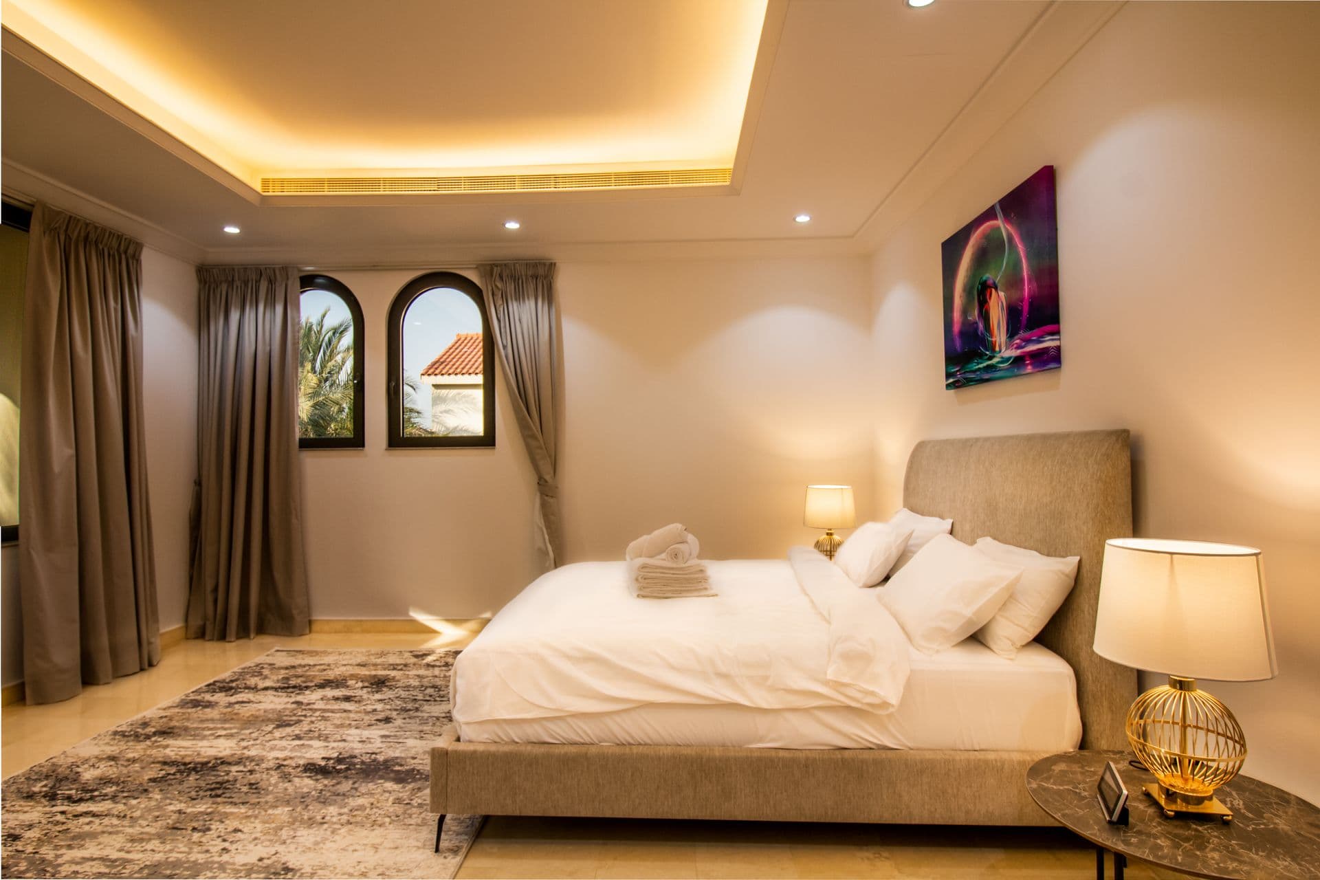 Bedroom in warm beige tones with bold framed artwork