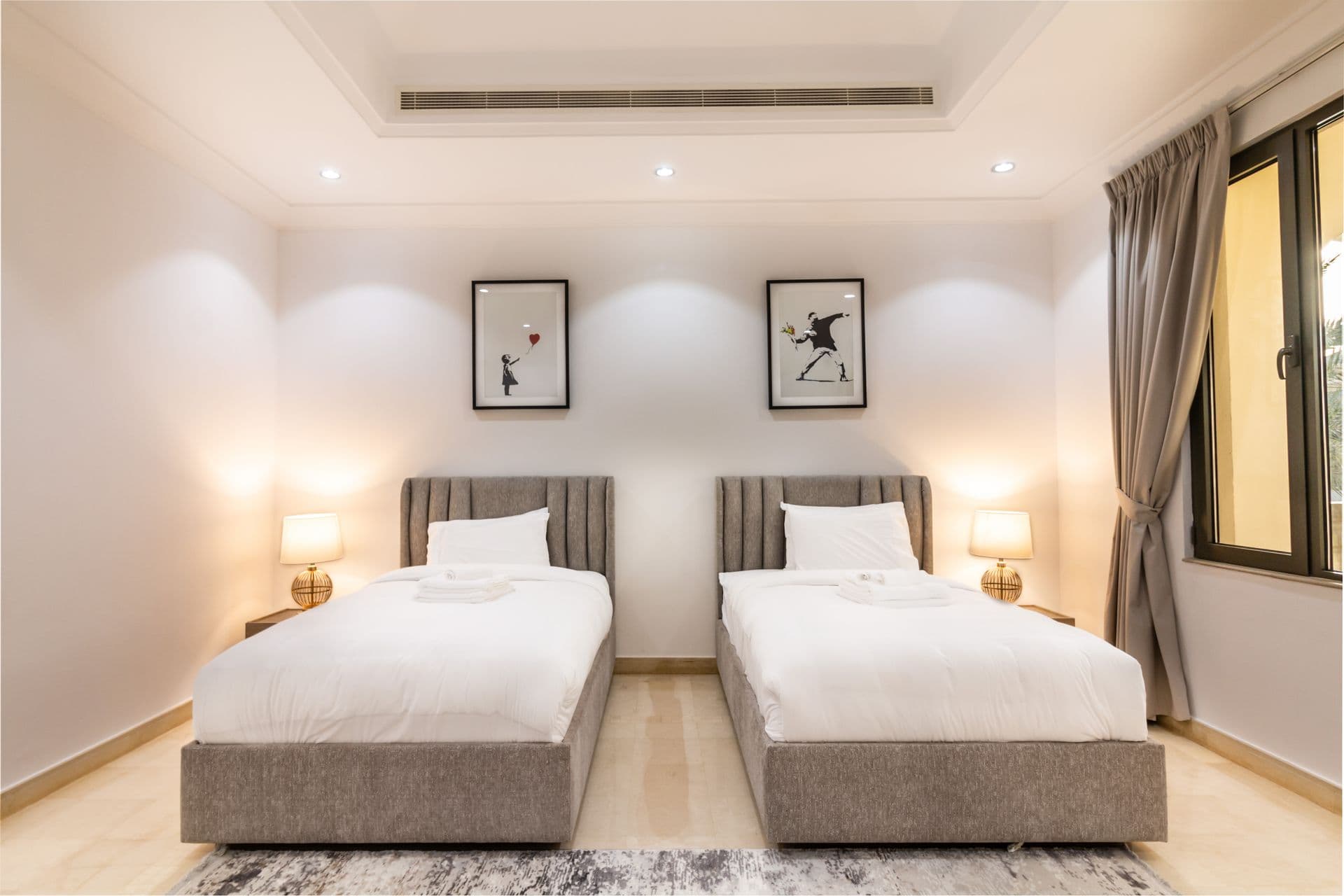 Twin bedroom with matching beds and sporting art prints