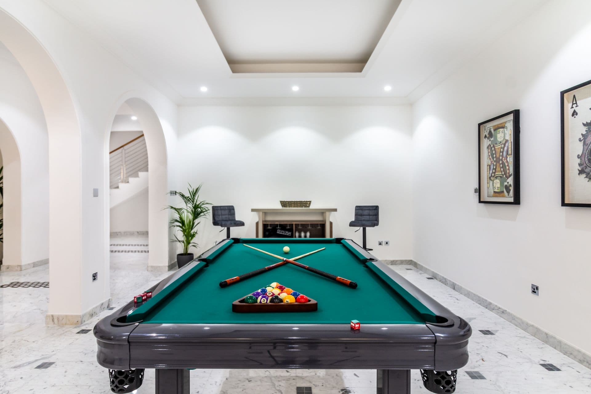 Games room with a full-size pool table under arched ceilings