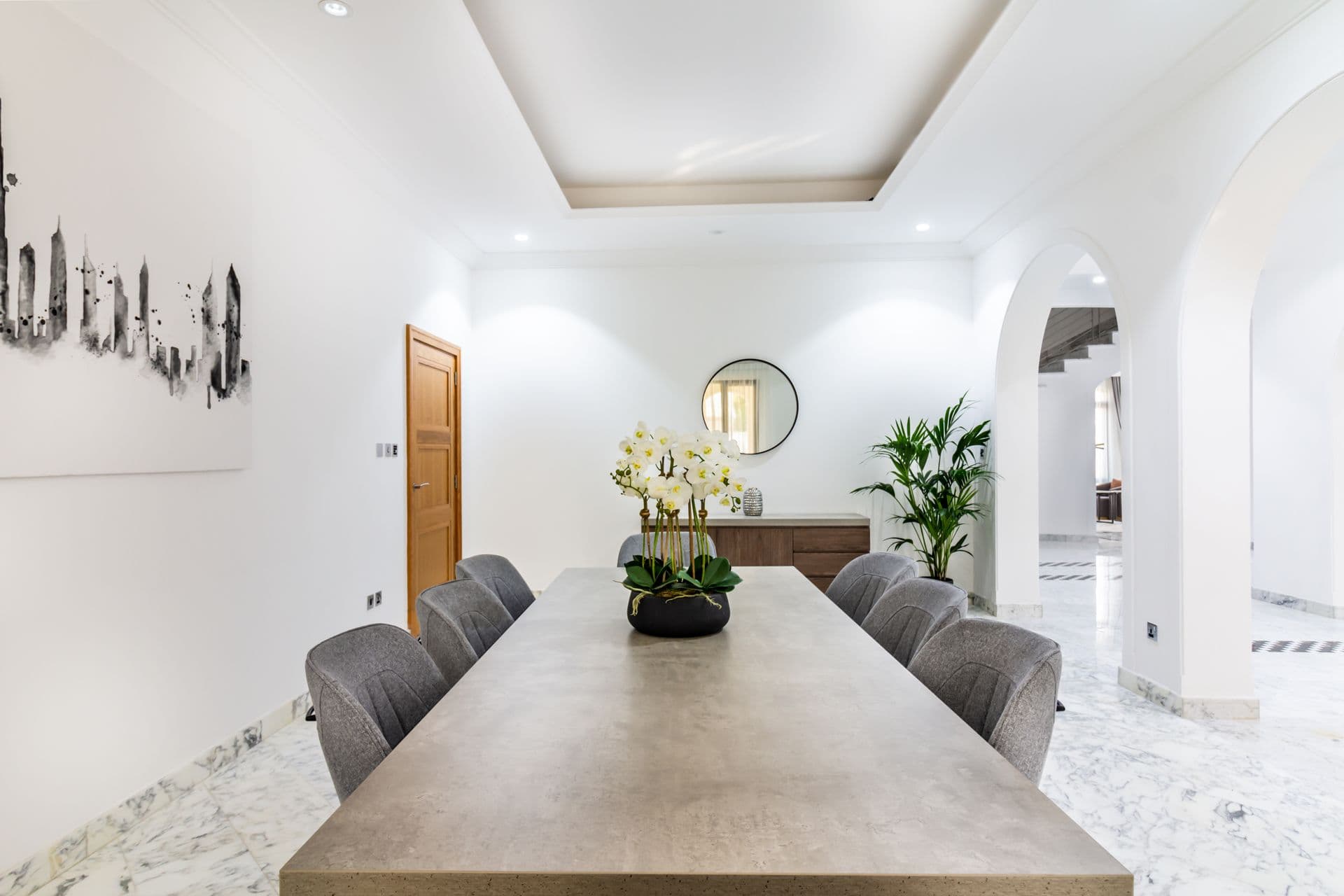 Marble hallway with arched doorways and fresh orchid display