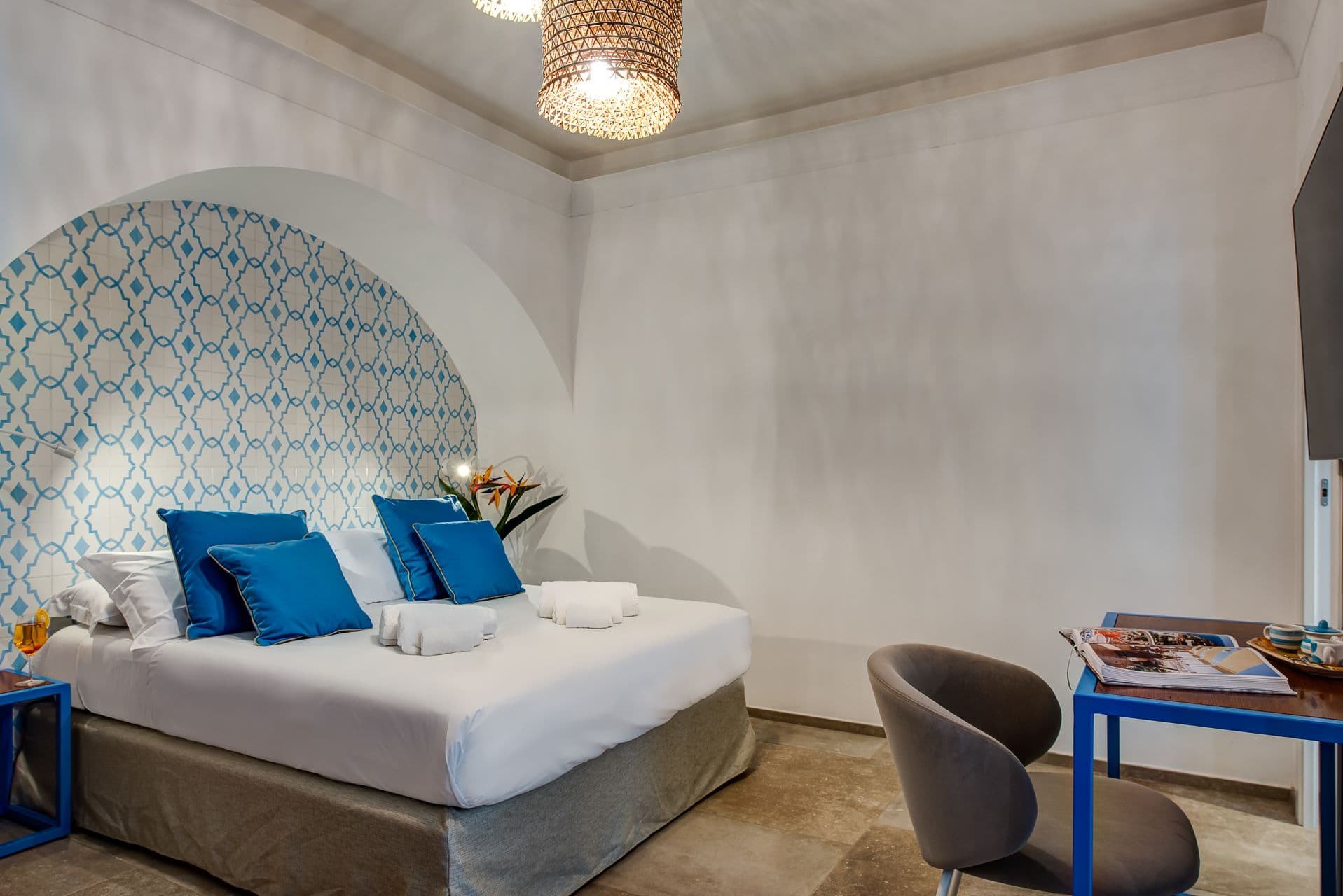 Bedroom with a decorative arched wall niche and patterned tile headboard wall at Mount of Love
