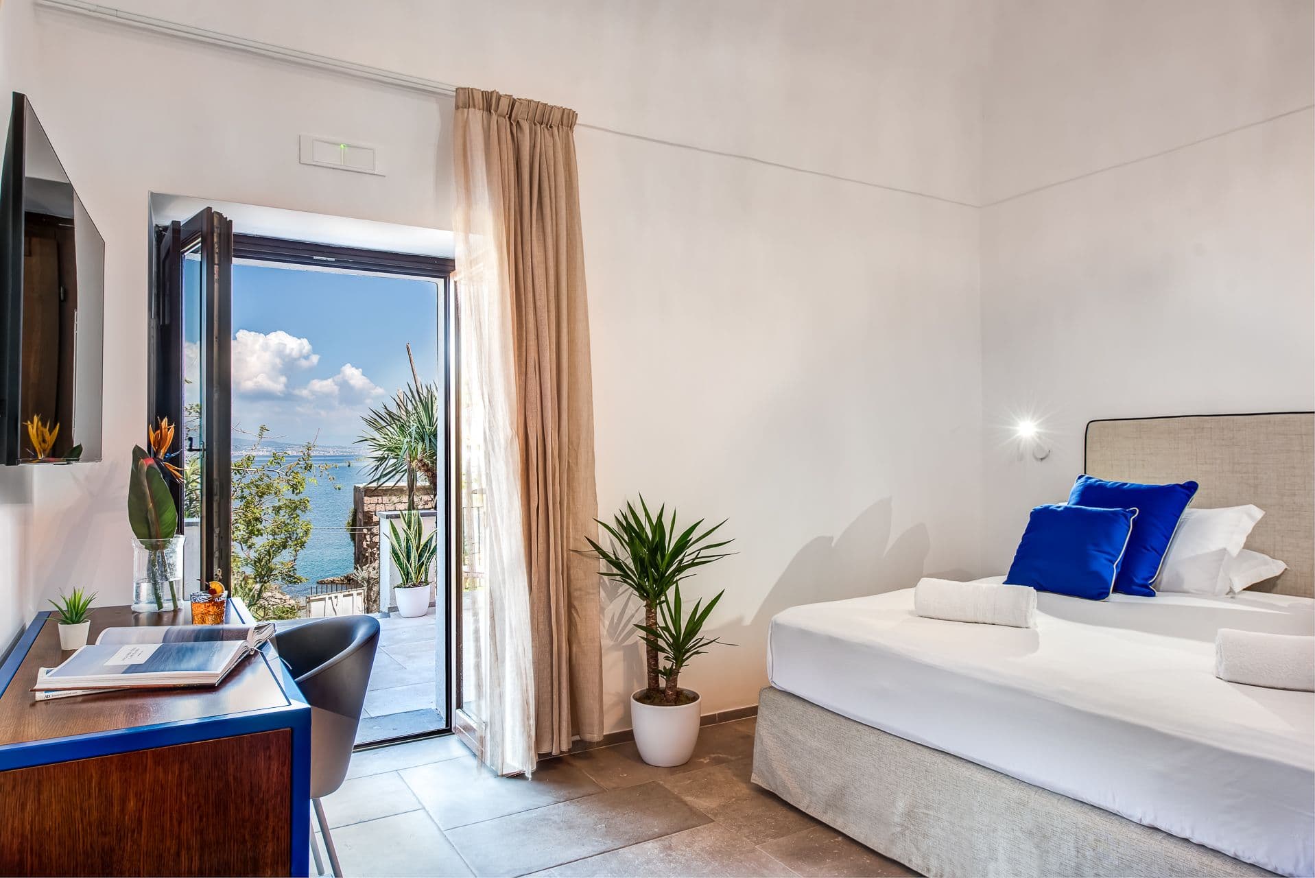 Bedroom with pendant lighting and glass doors leading onto a private terrace at Mount of Love