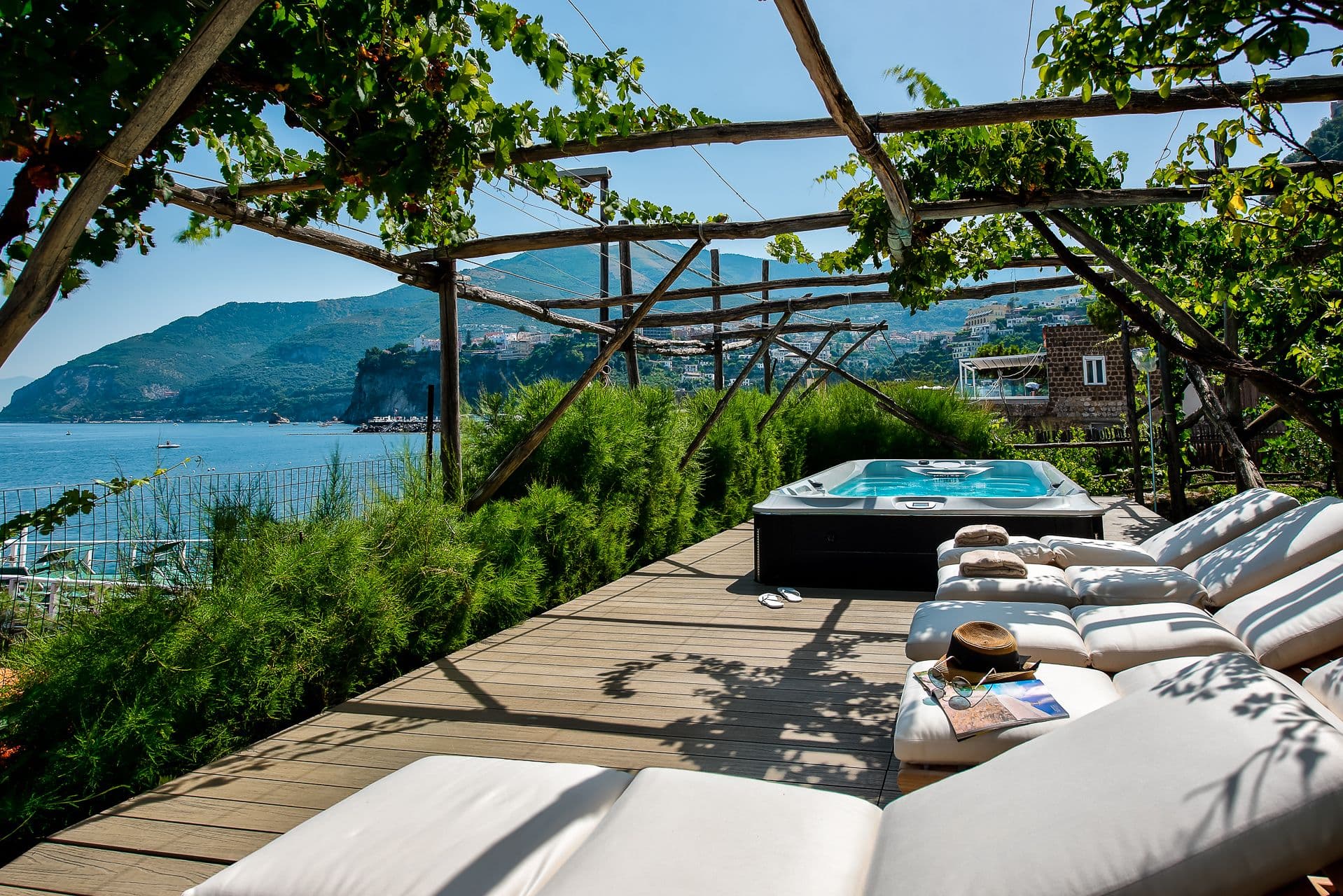 Sun loungers beneath a wooden pergola on a terrace overlooking the sea at Mount of Love
