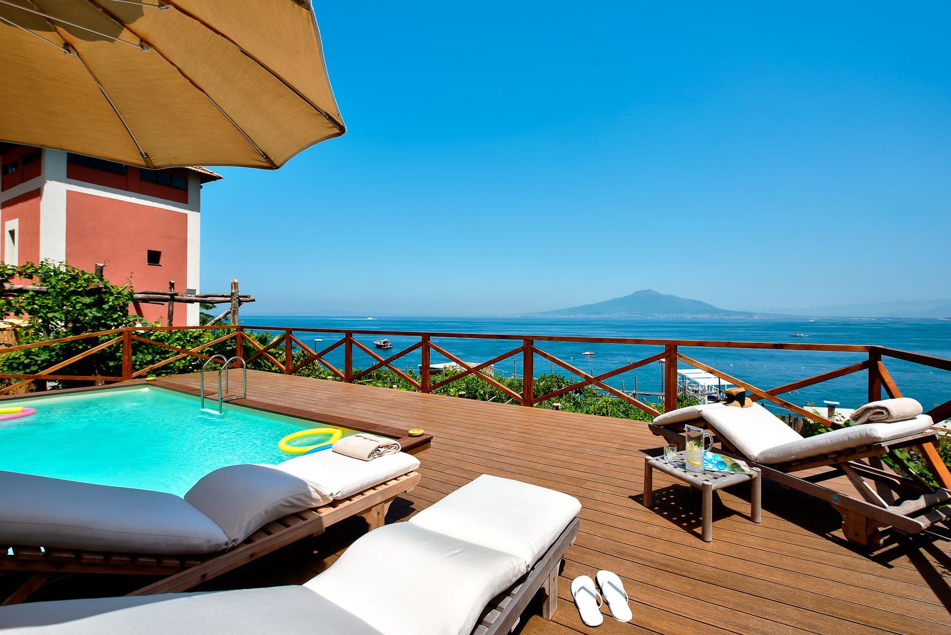 Sun loungers beside a plunge pool on a wooden terrace with panoramic views over the Bay of Naples at Mount of Love