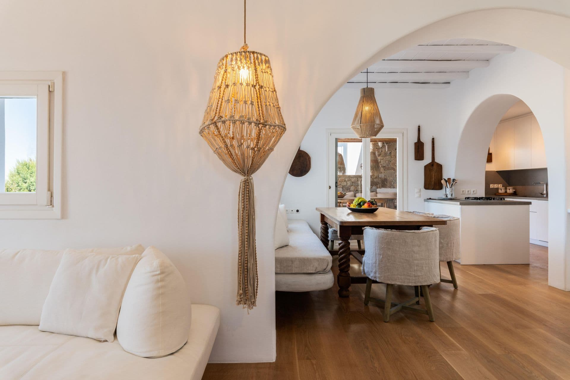 Bright living and dining room with white sofas and wooden dining table at Party Invitation