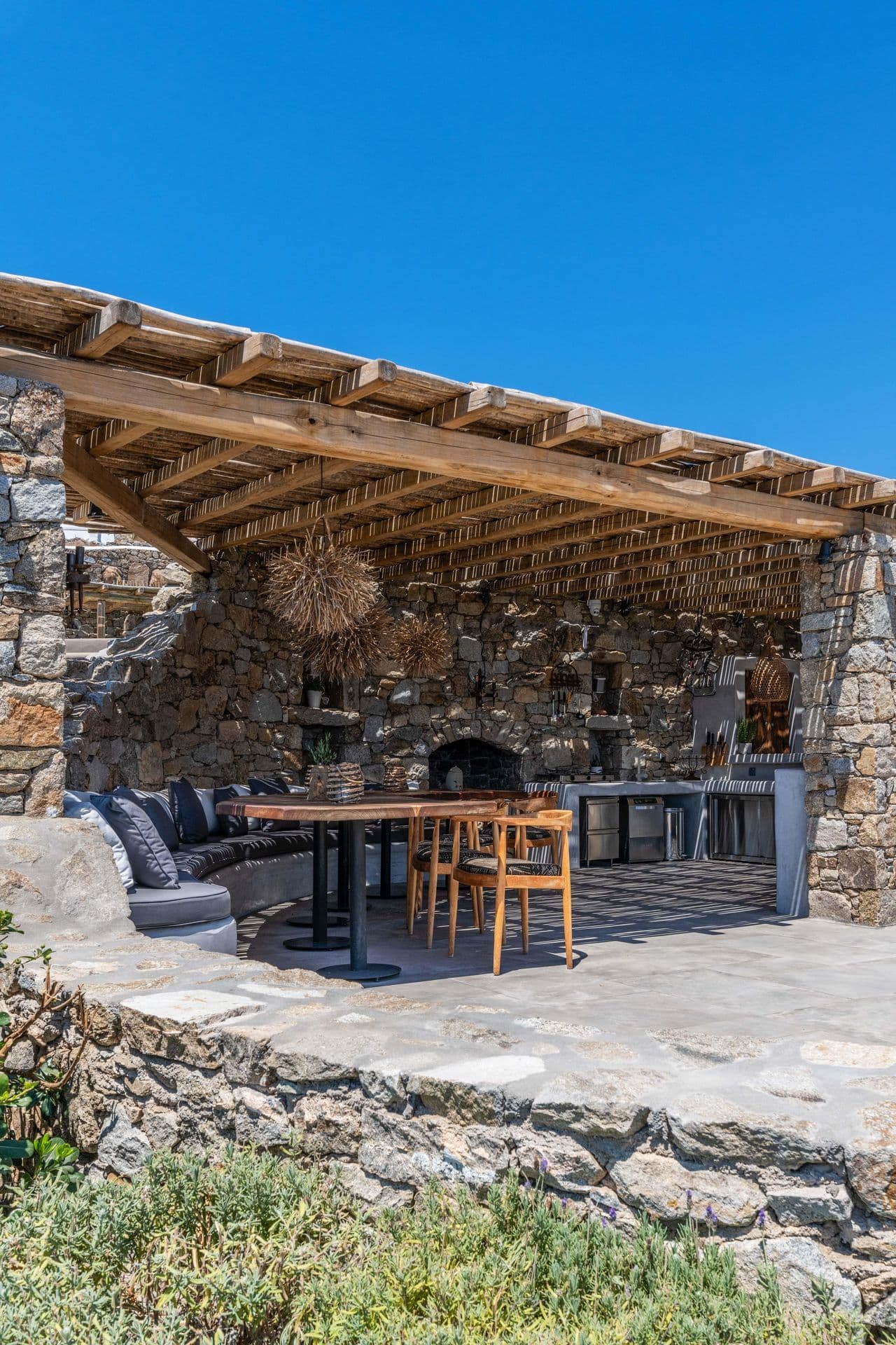 Covered outdoor kitchen with stone oven at Party Invitation villa